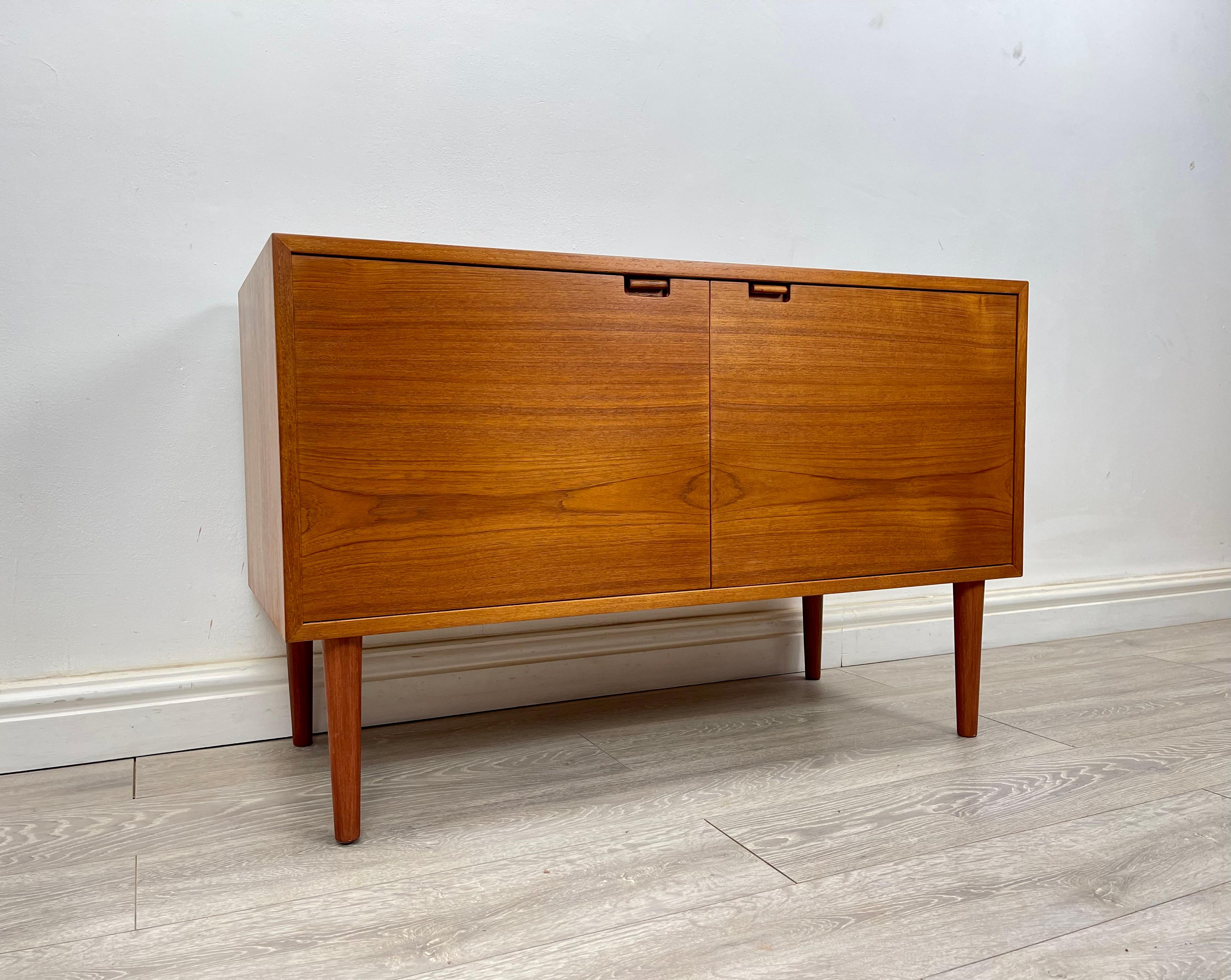 SIDEBOARD 
Stunning Midcentury Danish teak sideboard/ cabinet made by Sejling Skabe circa 1970s.

The sideboard stands on round tapered legs has stunning grain and golden patina throughout.

There’s two single cupboards with two adjustable