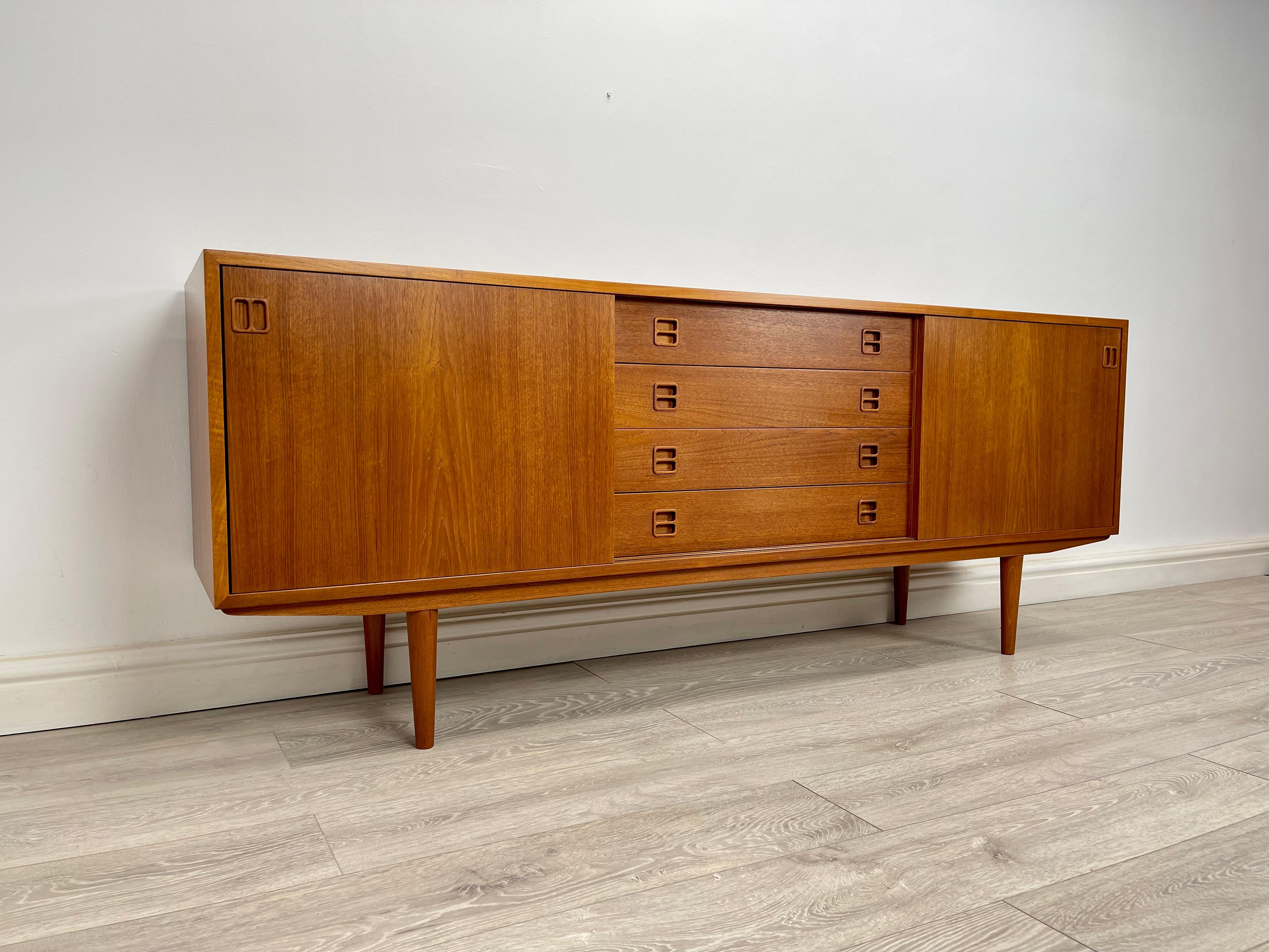 SIDEBOARD 
Stunning midcentury Danish teak sideboard circa 1970 . The sideboard has stunning grain throughout and golden patina throughout , there’s two single cupboard with sliding doors and two adjustable shelves . Bank of four drawers all run