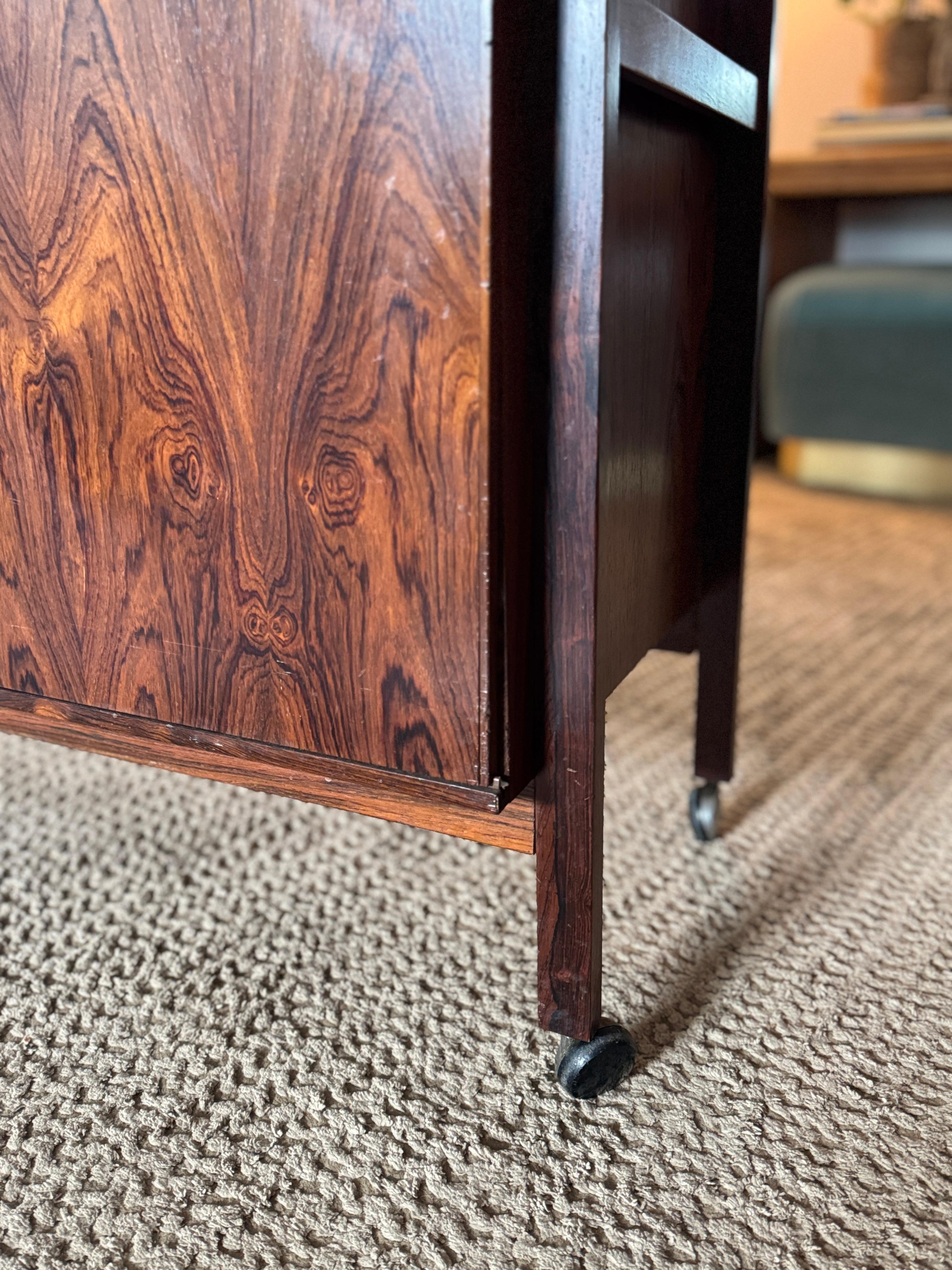 A Danish Mid Century expandable rosewood bar cart / cabinet, designed by Niels Erik and Glasdam Jensen for Vantinge Mobelindustri, circa 1960s. A beautiful example of Scandinavian design that perfectly balances function and style. The cart features