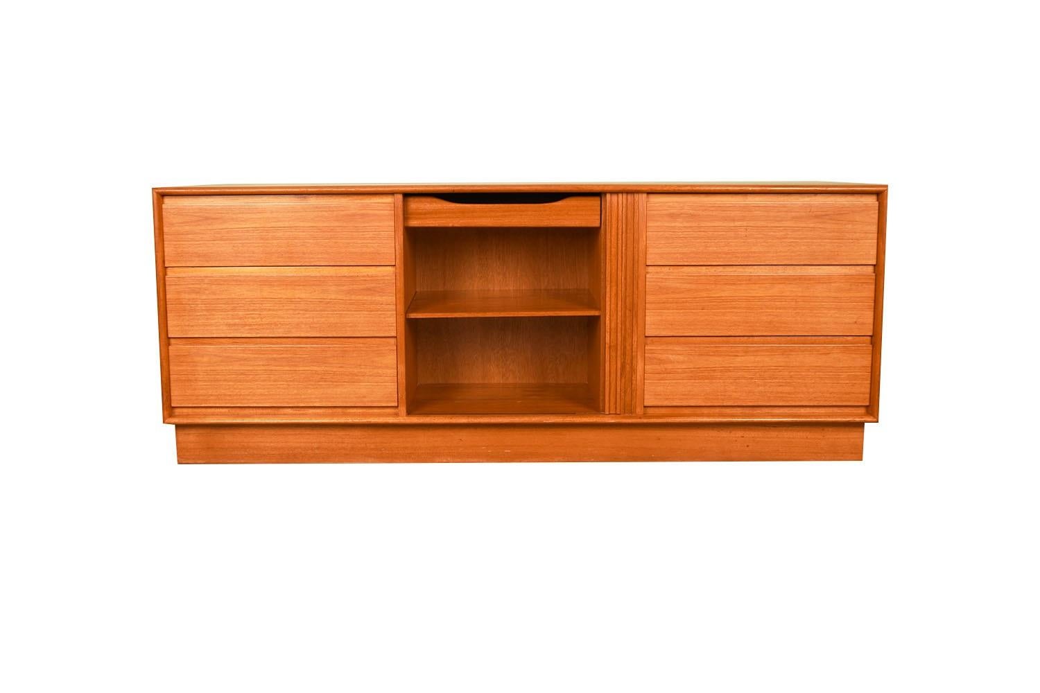 Beautiful mid-century modern tambour door dresser, circa 1970’s, by Danflex made in Denmark. Features six dovetailed drawers with sculptured drawer pulls, flanking one center tambour door that opens to reveal a storage area with one removable shelf