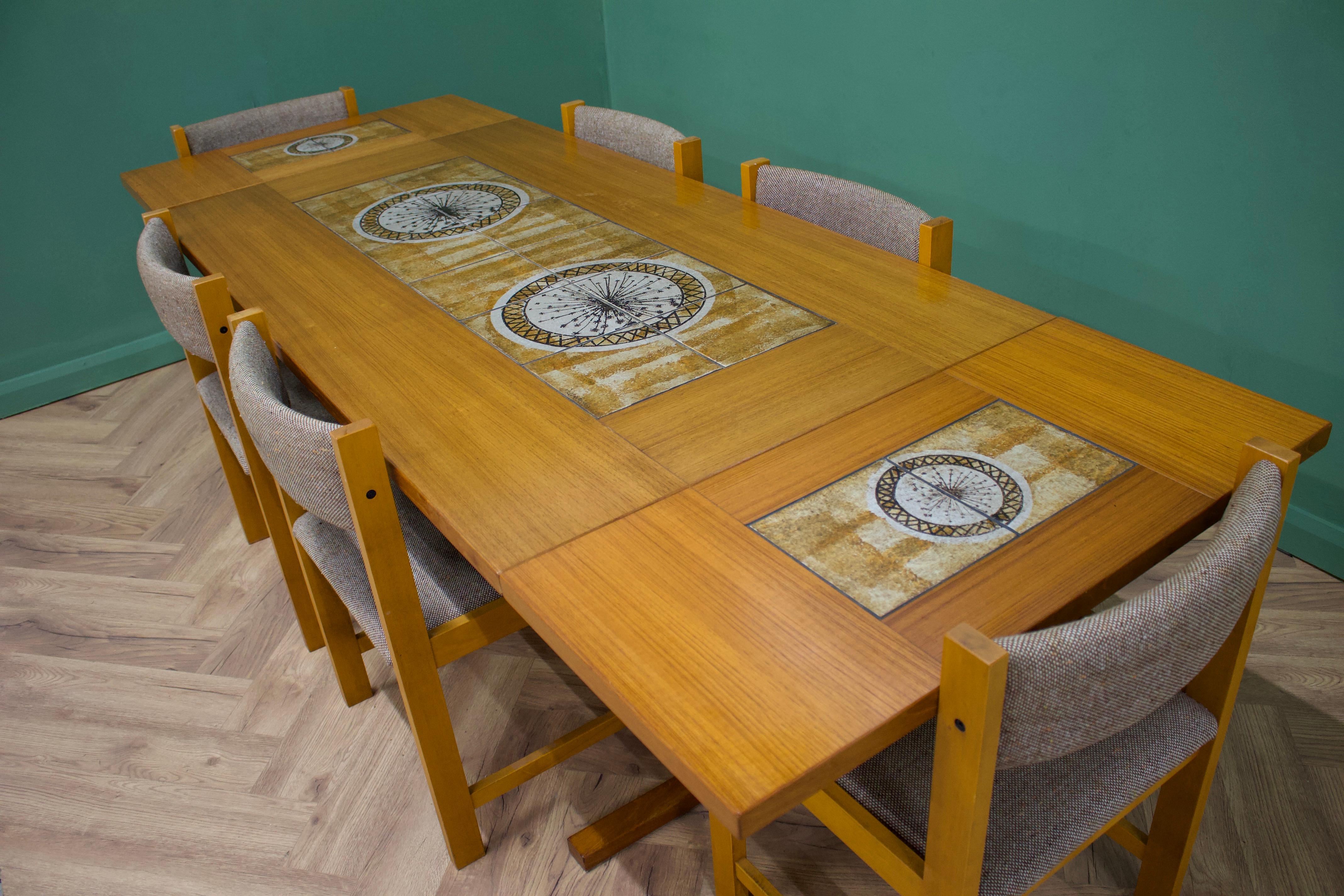 Une grande table de salle à manger en teck et 6 chaises de salle à manger de Gangso Mobler
Produit au Danemark dans les années 1970


Les tuiles du milieu et les feuilles ont été conçues par Poul Hermann Poulsen, un créateur de poterie danois