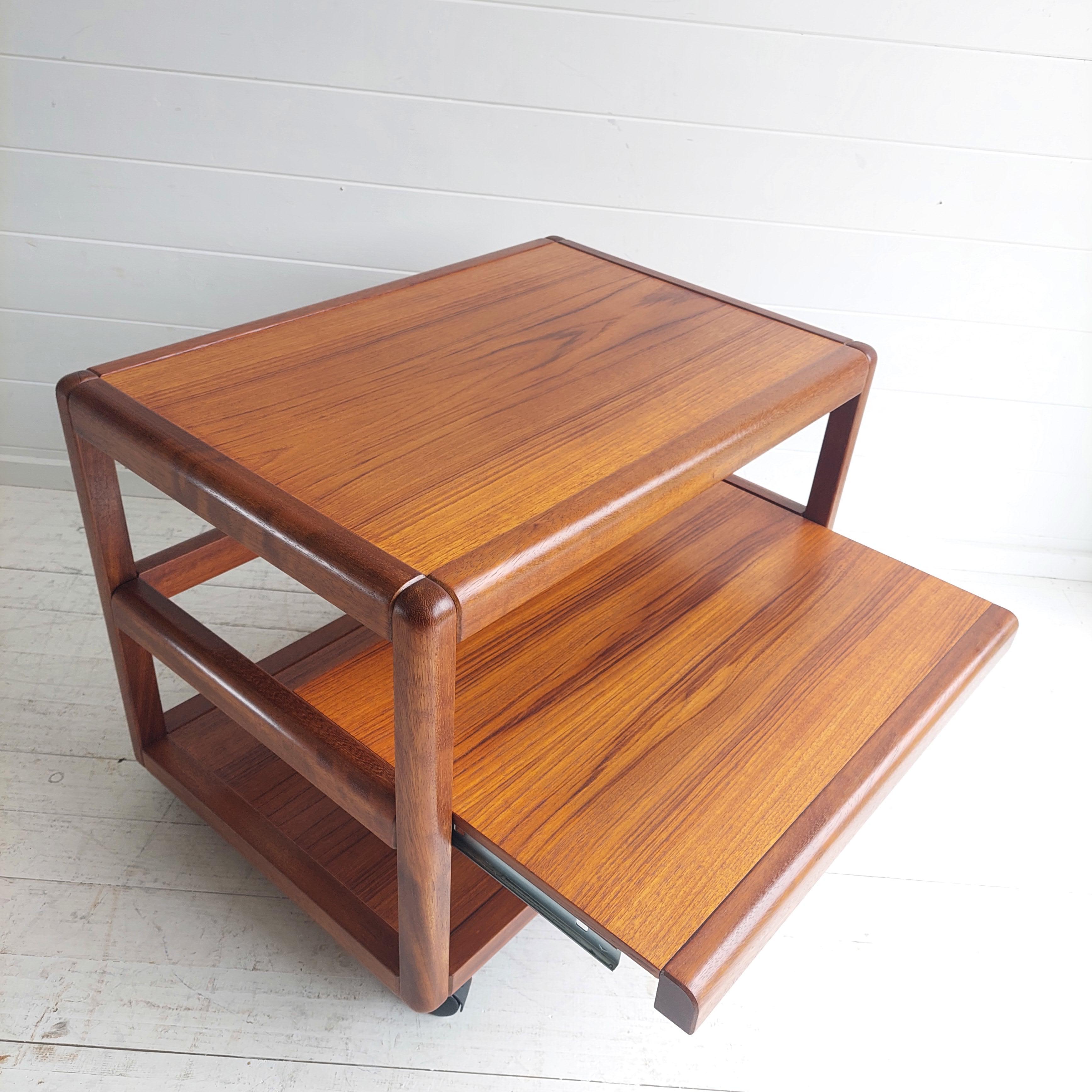 Mid Century teak serving trolly.
Stamped and Manufactured in Denmark
Charming and functional a vintage 3 Tier serving trolley 1960 - 1970s'.
Salin 5800 Nyborg style
Restored

The striking angled afromosia frame and legs support 3 tiers of teak