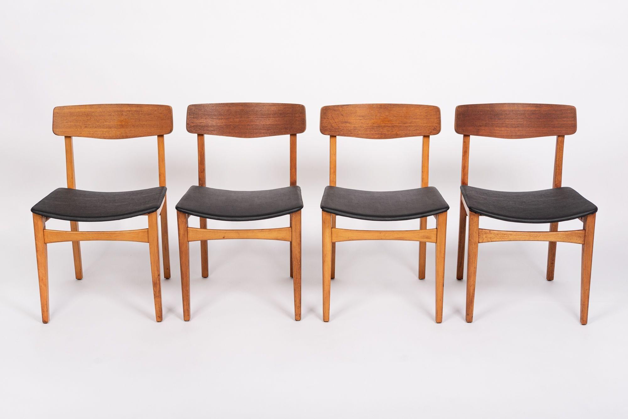 This set of four vintage mid century Danish modern teak wood dining chairs are circa 1960. These chairs have a classic Scandinavian design with clean lines and gentle curves. The chairs have a warm patina with sturdy, solid teak wooden frames, bent