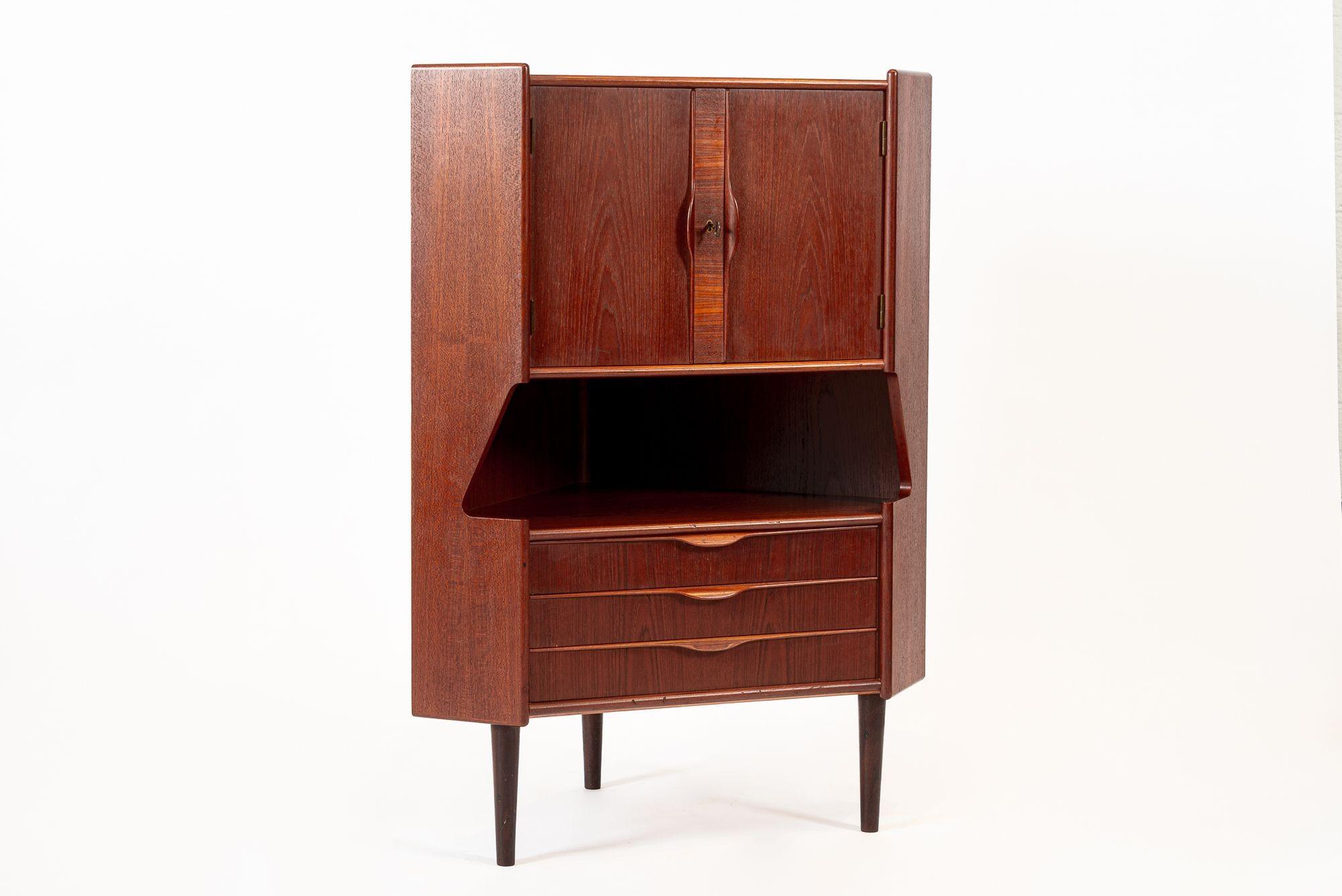 Questo eccezionale mobile bar angolare in teak danese della metà del secolo scorso, realizzato da Gunni Omann per Omann Jun (attr.), è stato prodotto in Danimarca nel 1960 circa. Il classico design scandinavo ha linee pulite ed eleganti ed è ben