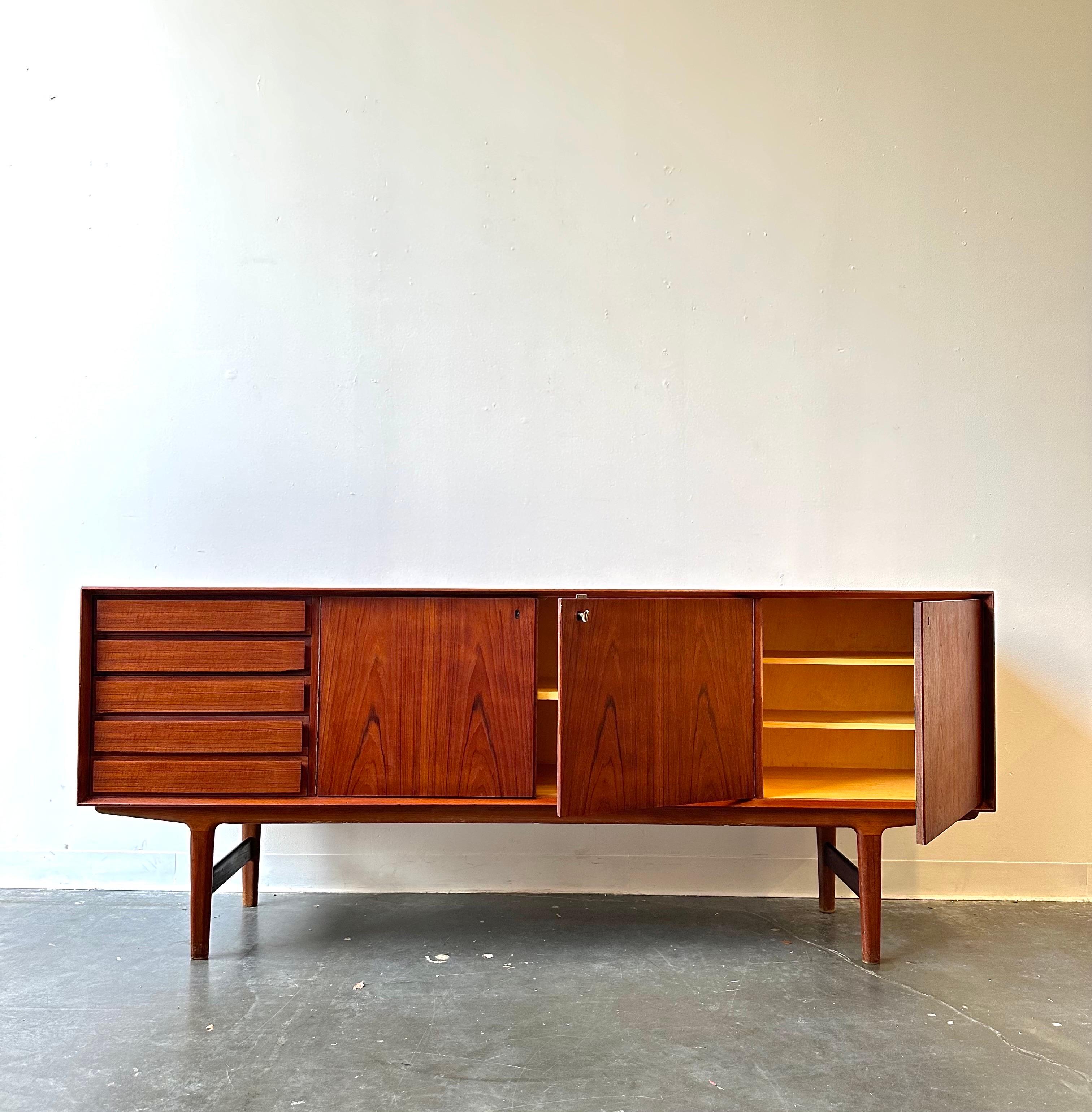 Fredrik Kayser Danish Teak Credenza Sideboard

This piece has 5 felt lined drawers, three doors with original key  that open up to a Maple Interior and adjustable a shelf. 

 Made in Norway   78.5, wide, 17.25, deep 32.5 high.  