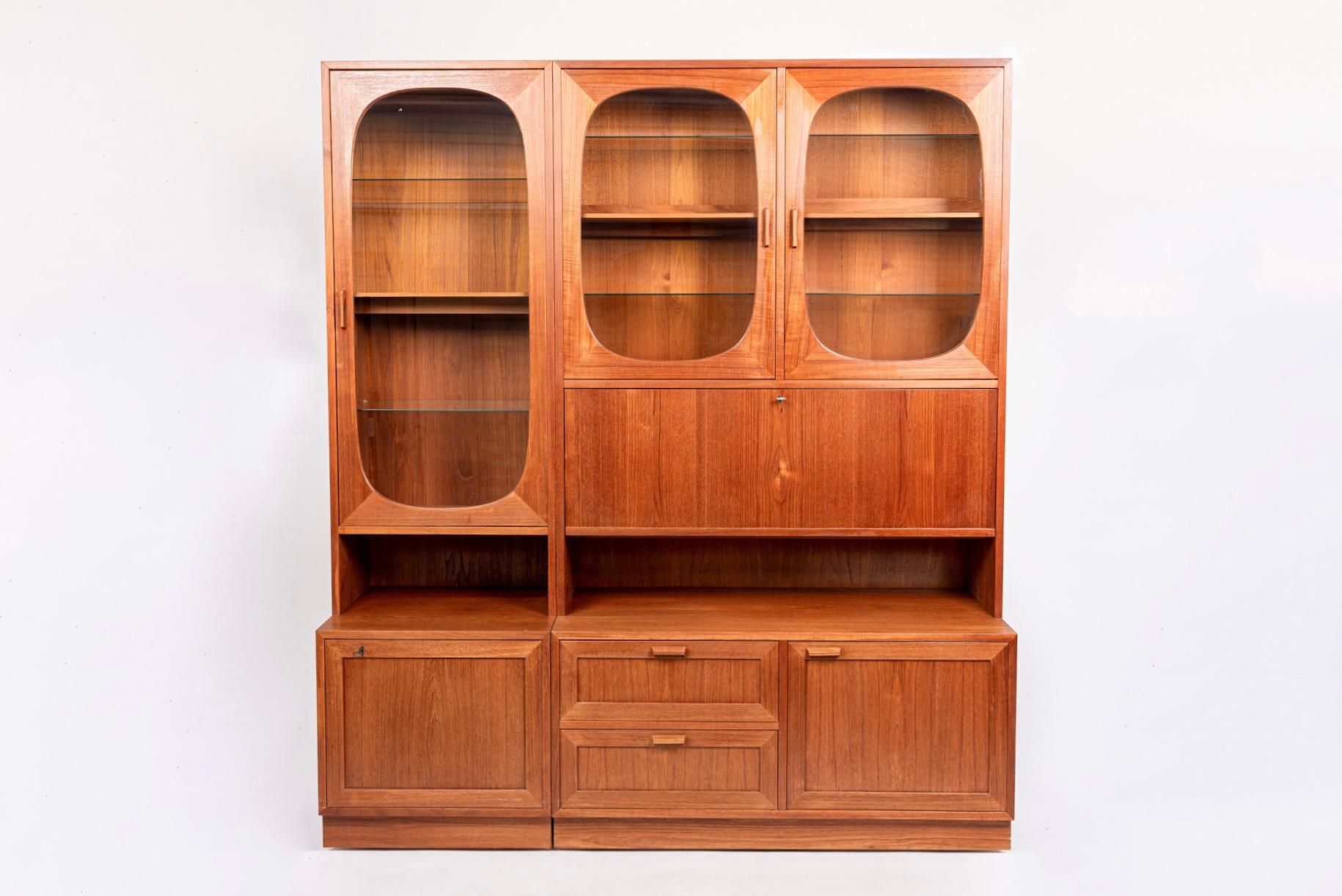 This exceptional set of matching vintage mid century Danish modern lighted display cabinets were made by Sejling Skabe in Denmark circa 1960. The cabinets are impeccably crafted from teak wood and the minimalist Scandinavian modern design features
