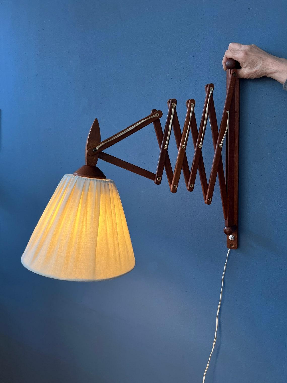 Mid century Danish style scissor lamp with wooden frame and beige shade. The scissor-mechanism allows you to extend the lamp from the wall. The shade can be adjusted too. The lamp requires an E27/26 (standard) lightbulb and currently has an