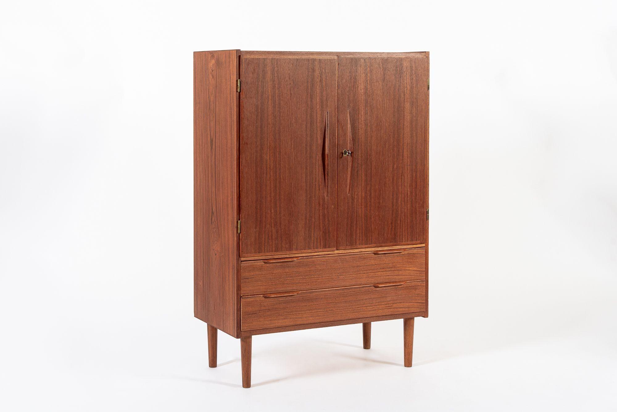 Questo mobile bar o ripostiglio in teak danese moderno della metà del secolo scorso è stato realizzato in Danimarca nel 1960 circa. Il classico design scandinavo ha linee pulite e minimaliste e un'elegante proporzione geometrica ed è ben realizzato
