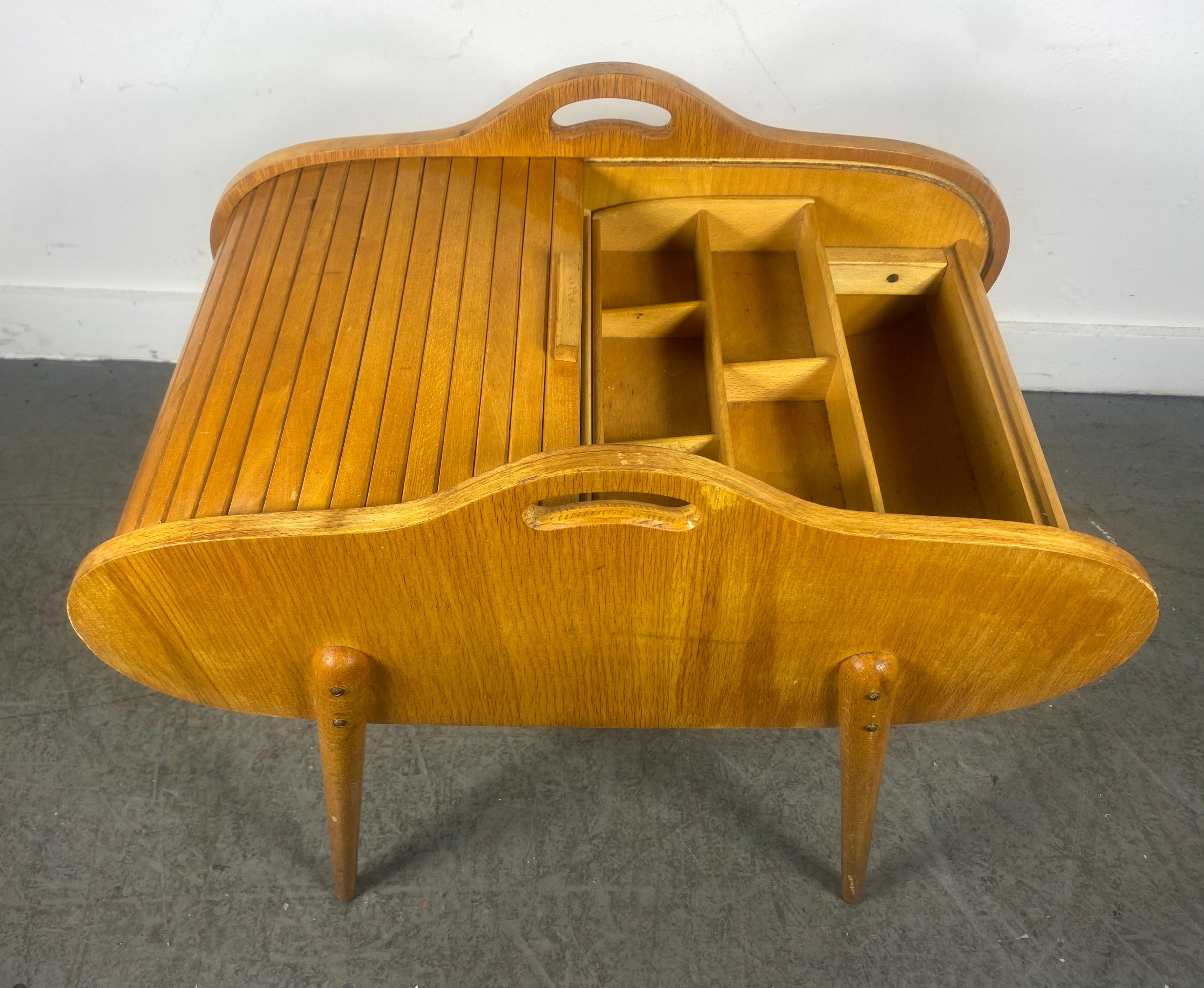 
Mid-century Danish sewing box with a tambour roll top dating from the 1950/60s.
The top rolls around the whole box-body forward and back.

Larger than the average sewing box with mid-century Danish styling and a beautiful light wood finish.
A very