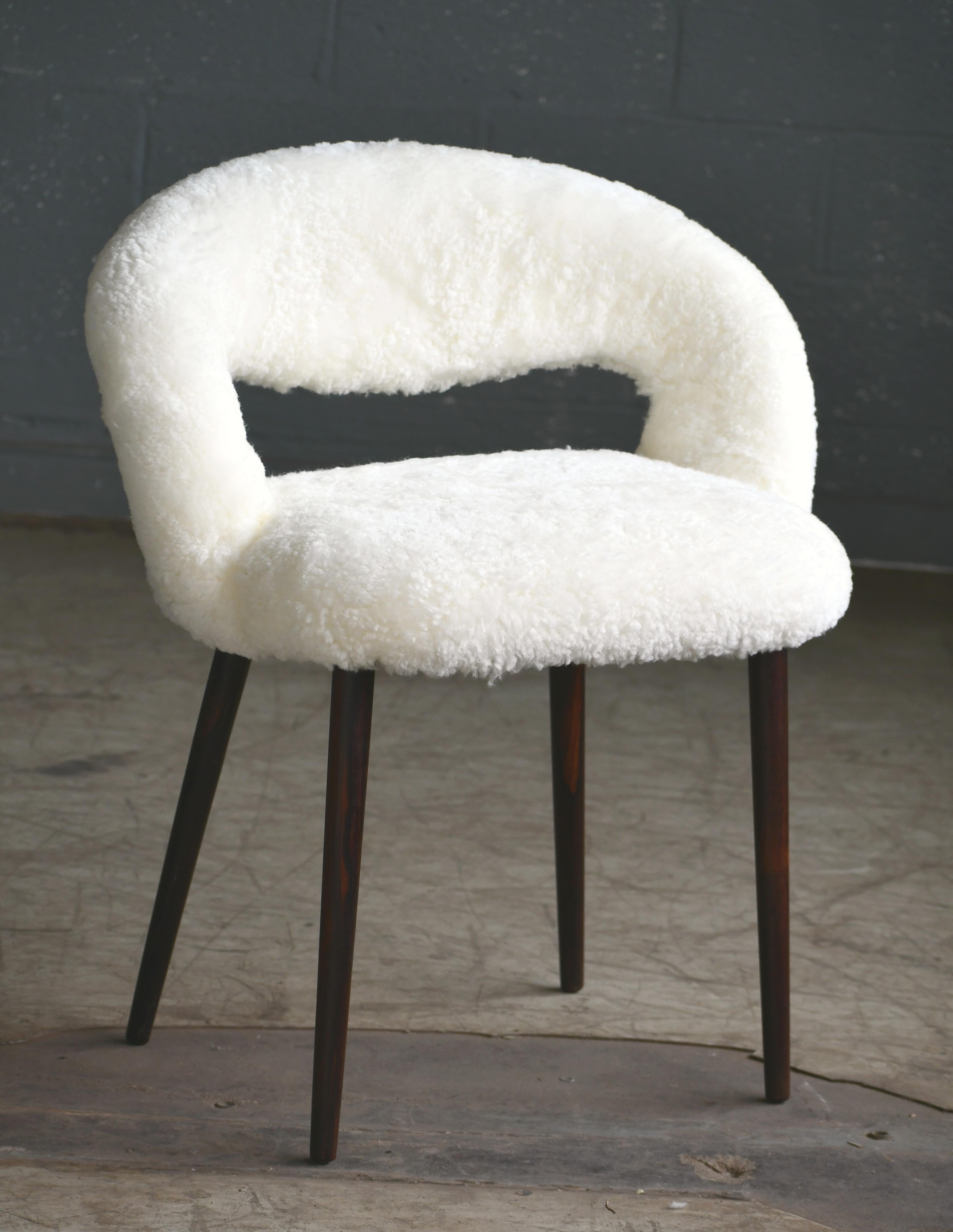 Super stylish, comfortable and highly coveted dressing or vanity chair by Frode Holm made in the 1950s. The chair is newly upholstered genuine shearling and is a fantastic addition of luxury to any bedroom or powder room. Great vintage condition