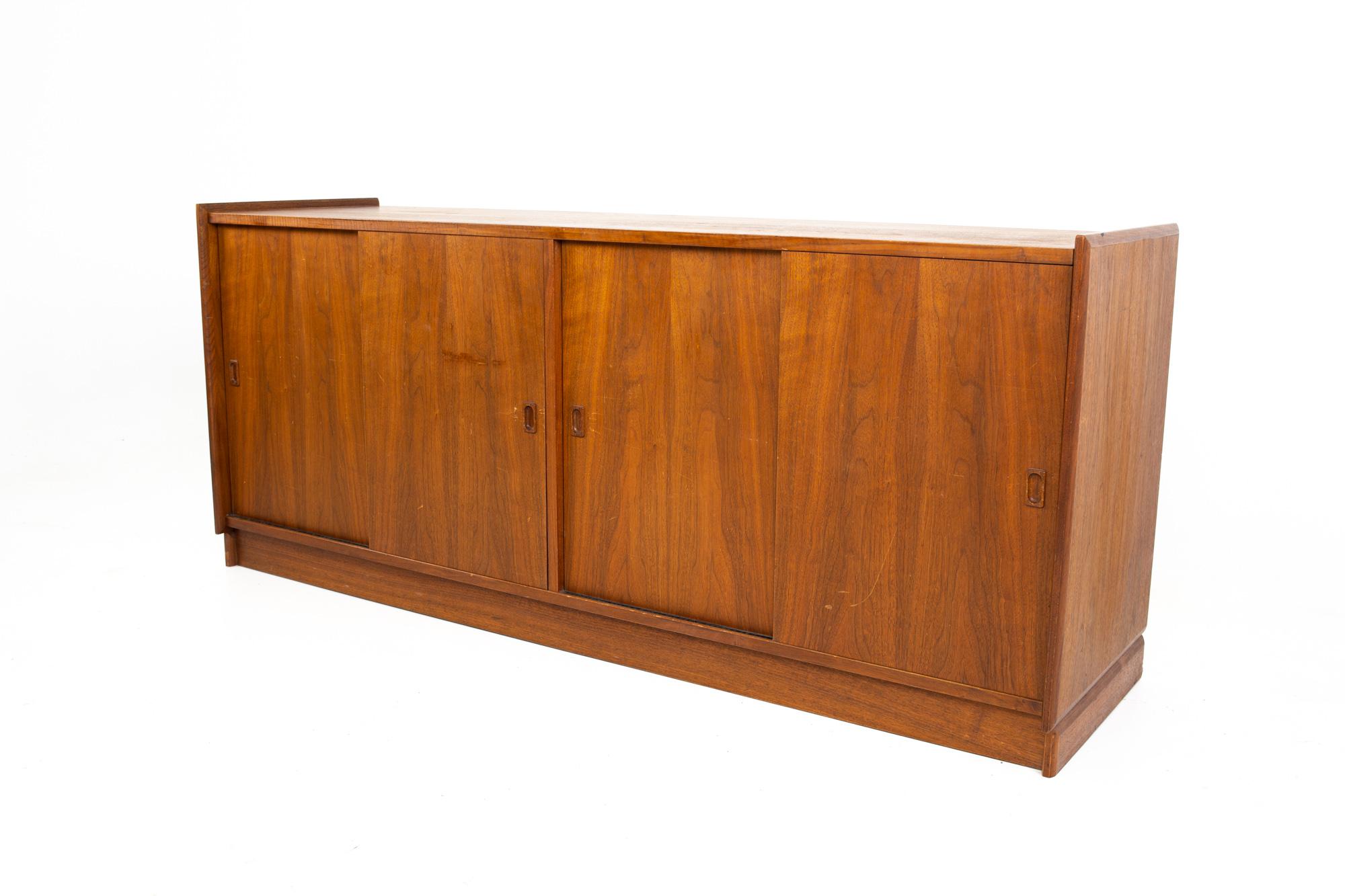 Mid century Danish walnut floating sliding door credenza
Credenza measures: 64.75 wide x 18.25 deep x 27.75 inches high

All pieces of furniture can be had in what we call restored vintage condition. That means the piece is restored upon purchase