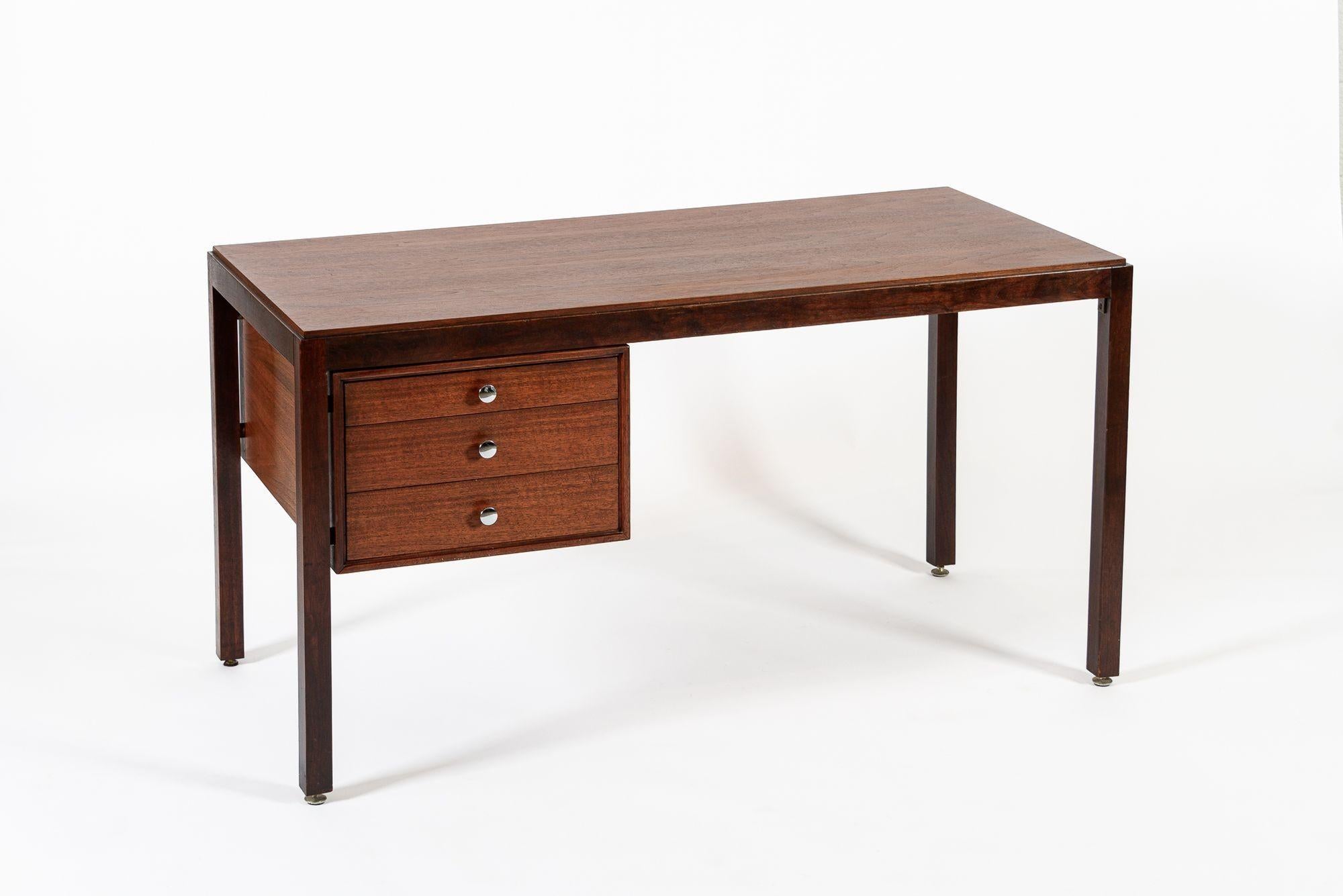 This vintage mid century Danish modern walnut and mahogany wood writing desk in the style of Finn Juhl is circa 1960. The desk is well-crafted from walnut and mahogany with a distinctive two-tone effect and beautiful natural grain. The Scandinavian