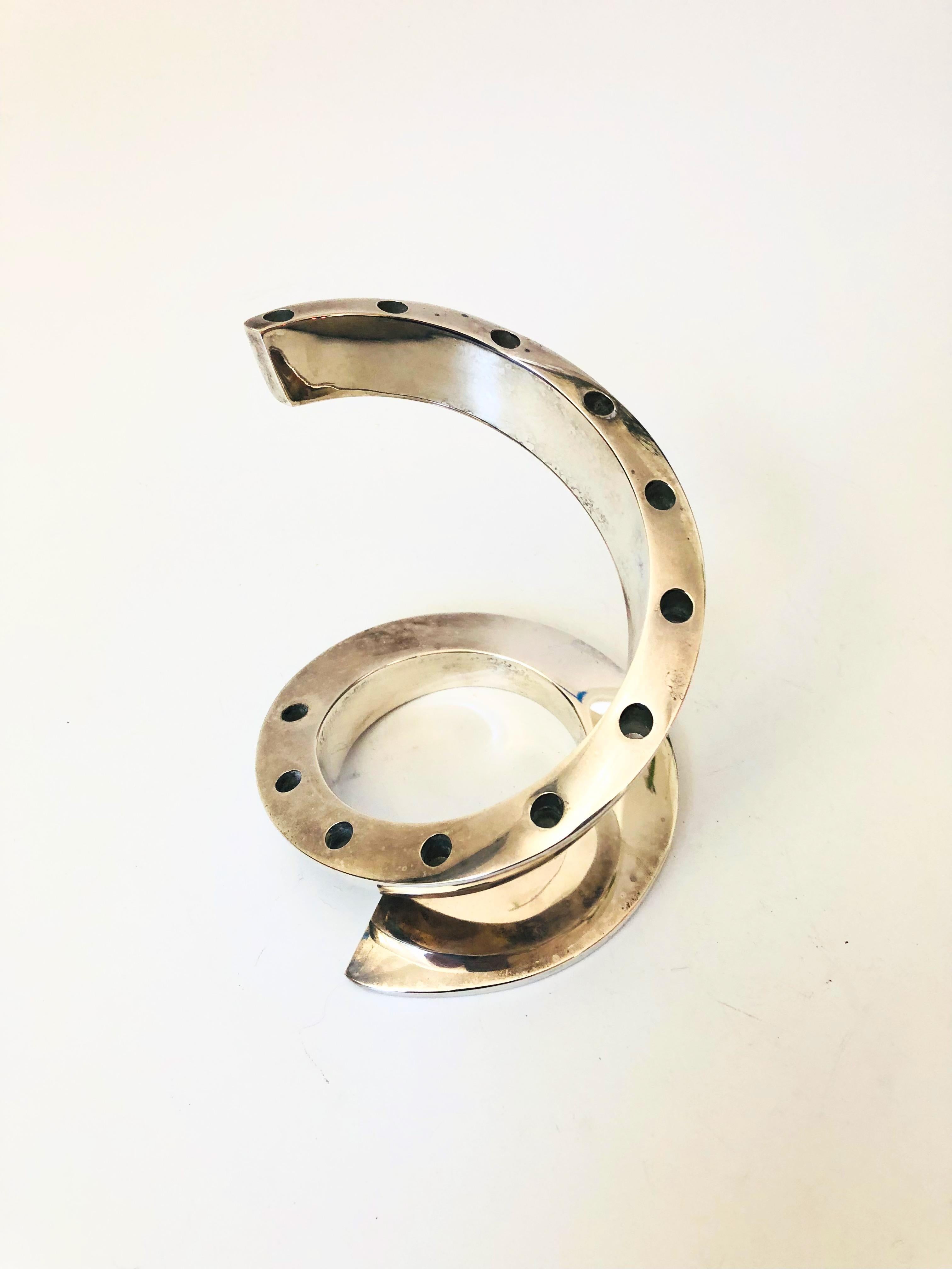 A mid-century silver plate candle holder designed by Bertil Vallien for Dansk. Great sculptural spiral shape, holding up to 12 tiny taper candles. Marked 
