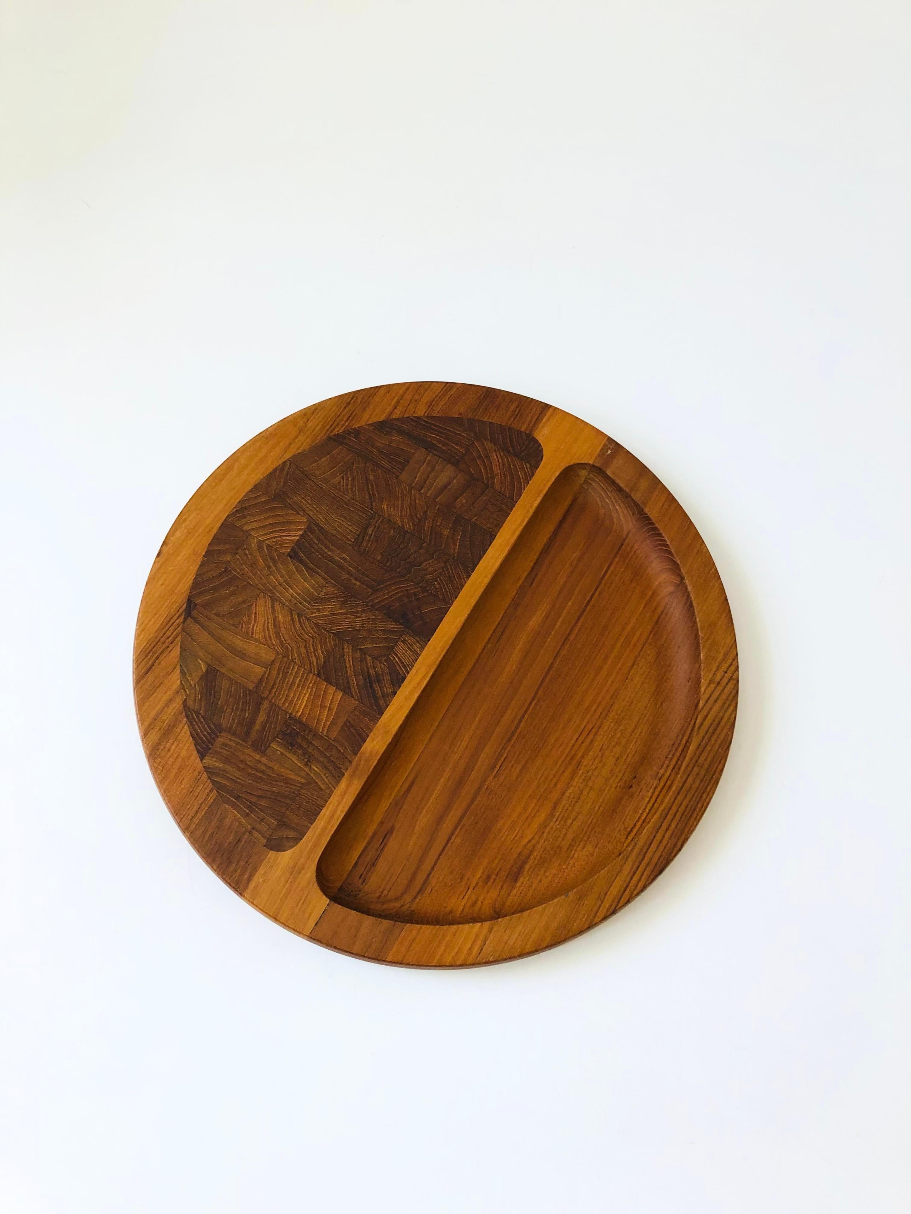 A mid century Danish teak cutting board and serving tray designed by Jens Quistgaard for Dansk. Circular shape with one flattered side and a recessed semi circle for serving. Marked on the base 