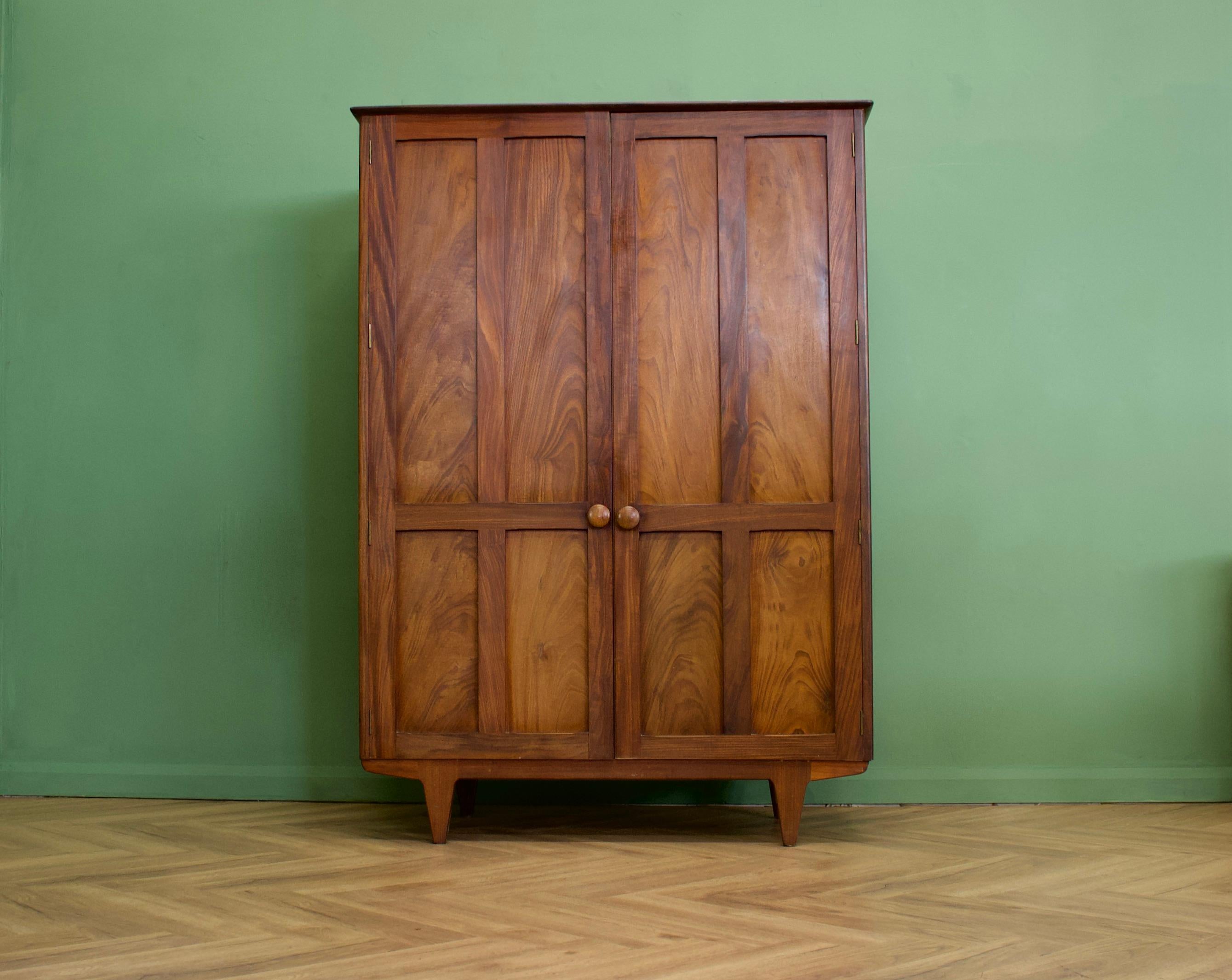 A dark teak freestanding wardrobe by John Herbert for Younger - circa late 1950s -
Internally there is a hanging rail the full width
The attractive legs are tapered and the handles are solid teak
This is a beautiful quality piece