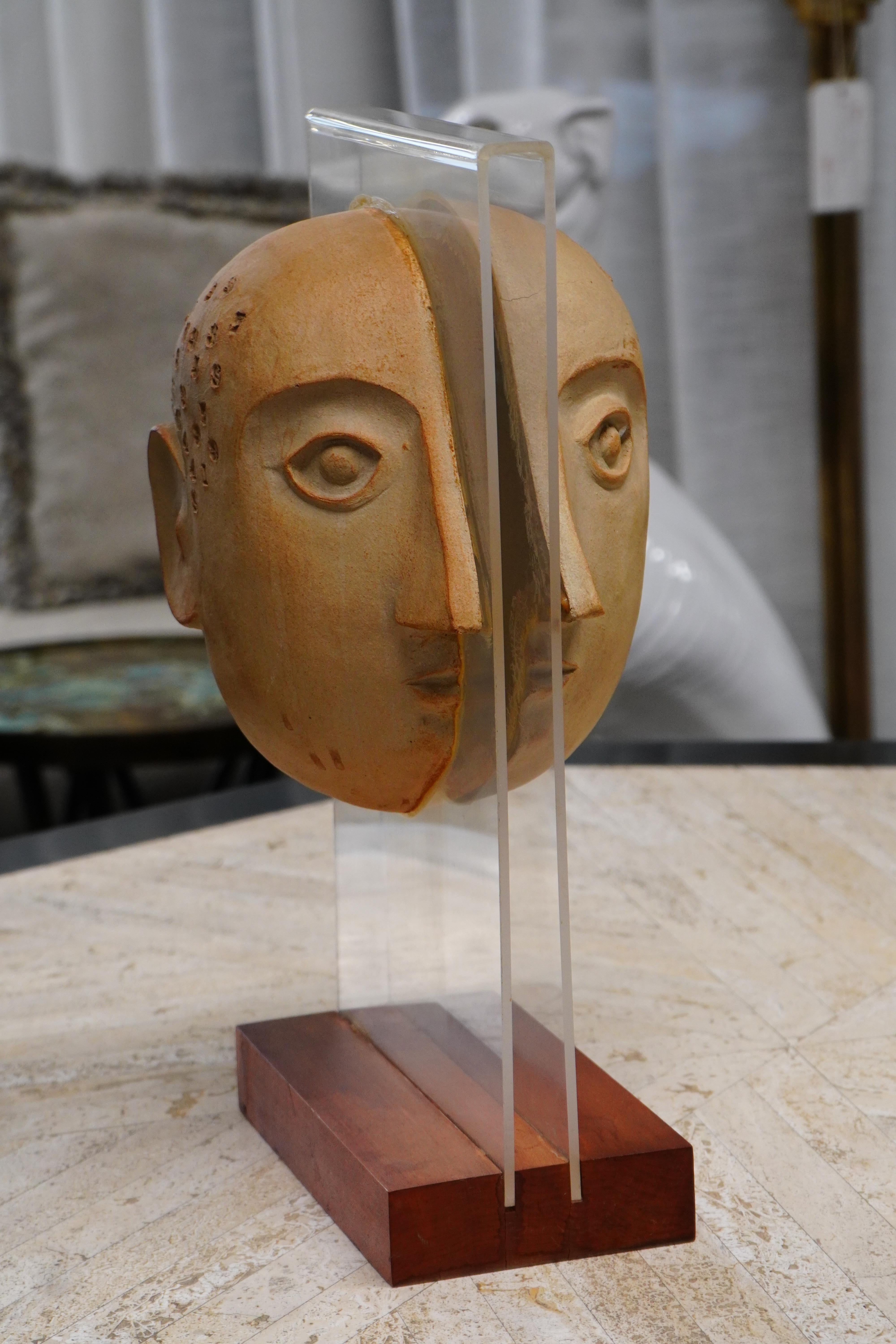 A stoneware sculpture created by artist David Gill for Bennington Potters. It features a head with imprinted numbers, made of two halves attached to a leucite stand.
In the 1950s, Gil co-founded Bennington Potters with other prominent artists to