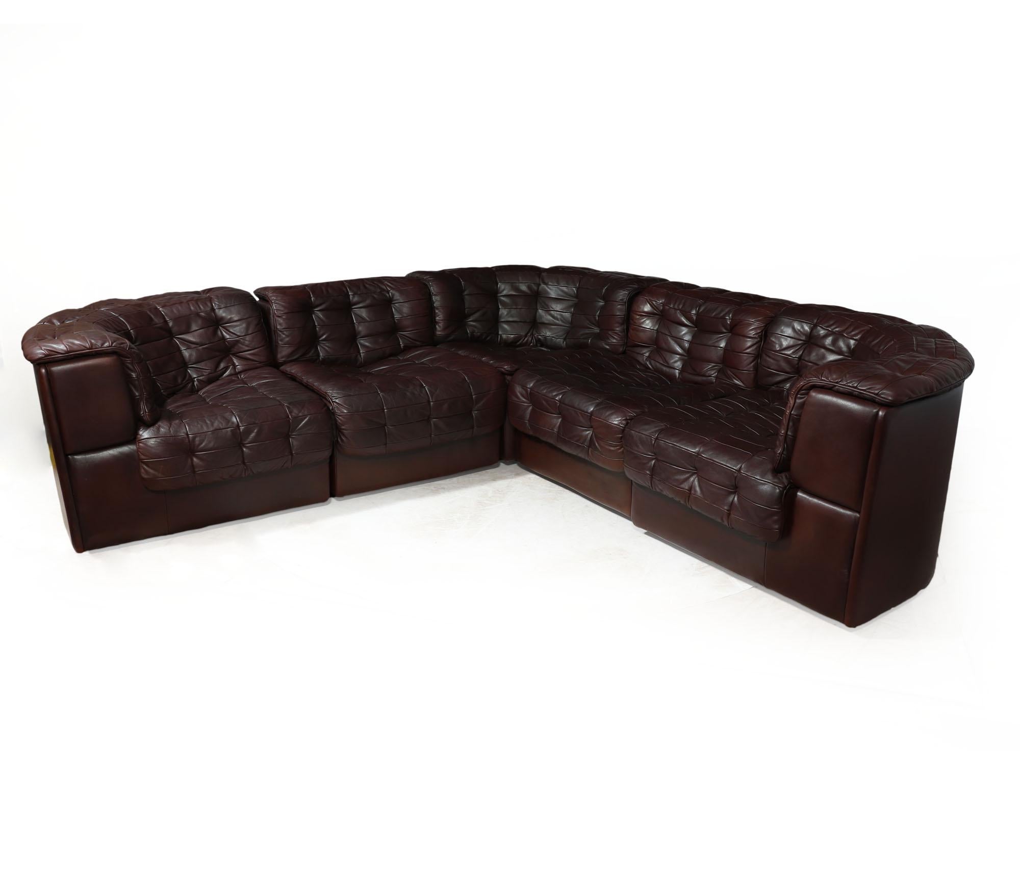 DE SEDE - DS11 
Manufactured in the 1970s by the esteemed sofa makers De Sede, this modular corner sofa showcases a unique patchwork leather design, featuring one corner element, two seating elements, and two end elements. Crafted in rich brown