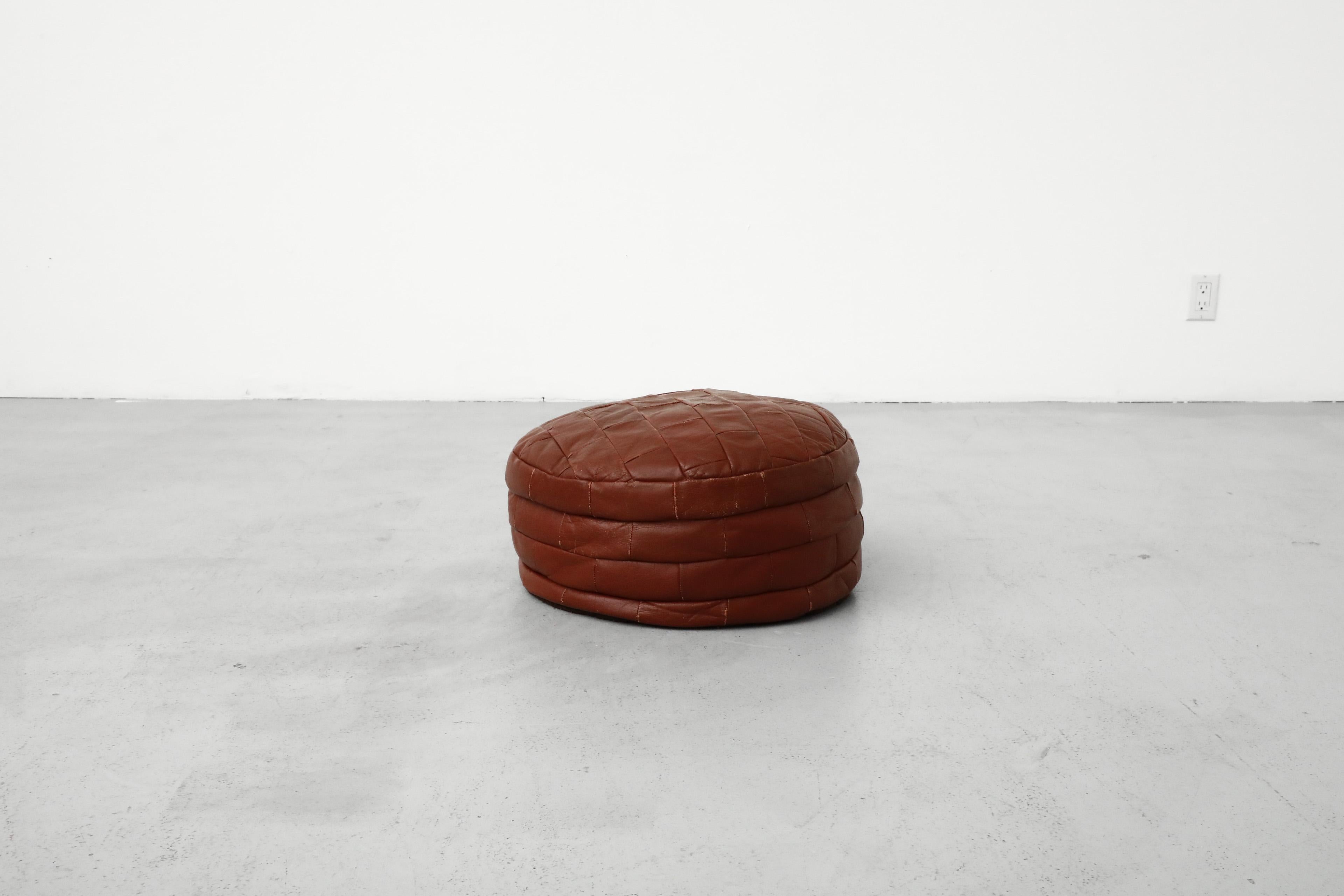 Pouf rotondo patchwork di metà secolo in pelle patchwork rosso intenso. In condizioni originali, con alcuni segni di usura e graffi dovuti all'età e all'uso. Sono disponibili anche altri pouf, elencati separatamente.