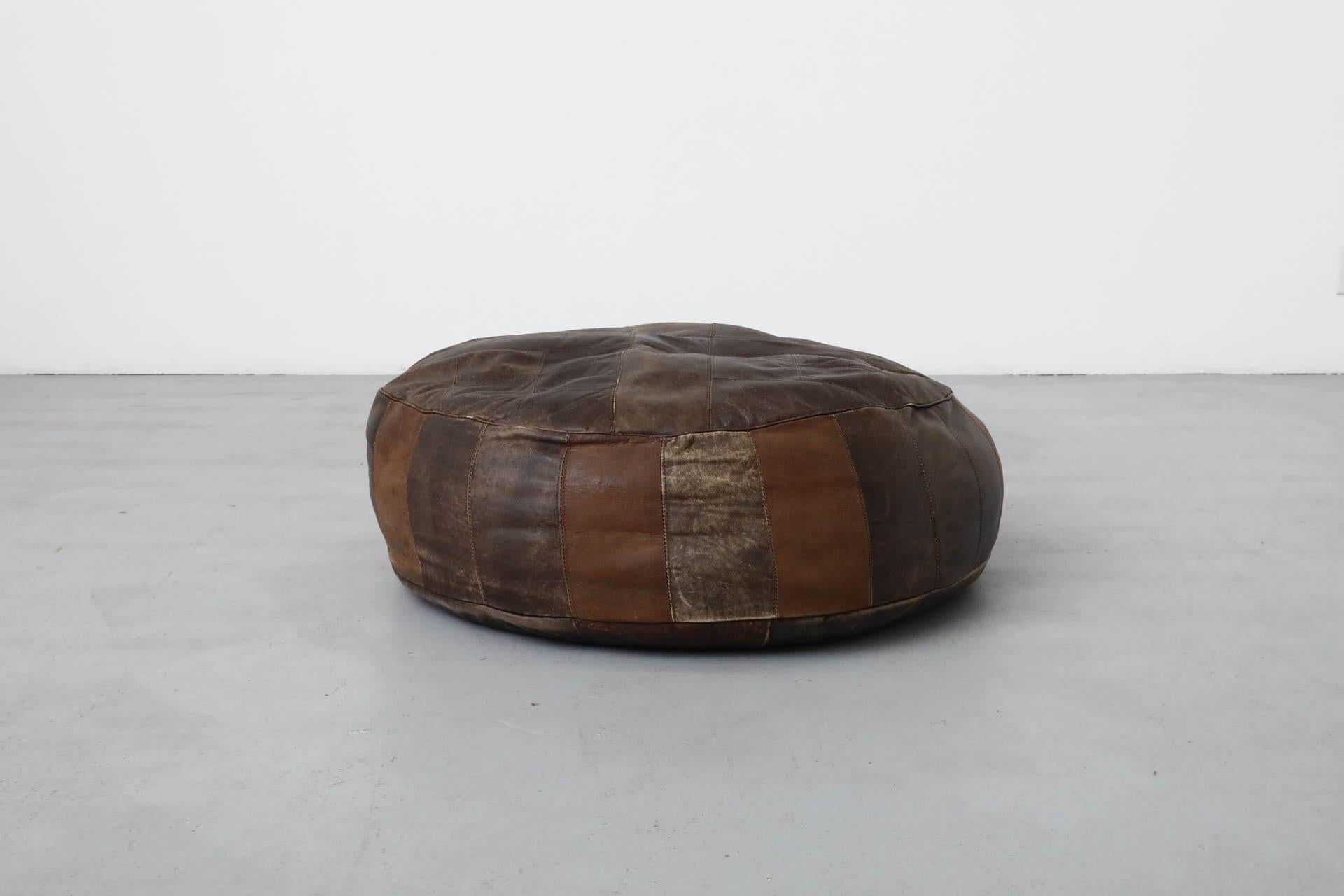Pouf olandese di metà secolo ispirato a Stitch by Stitch, in pelle marrone scuro, con cuciture patchwork. Questo bel pezzo, grande e pesante, è in condizioni originali, con qualche segno di usura visibile e una patina ricca e profonda, coerente con