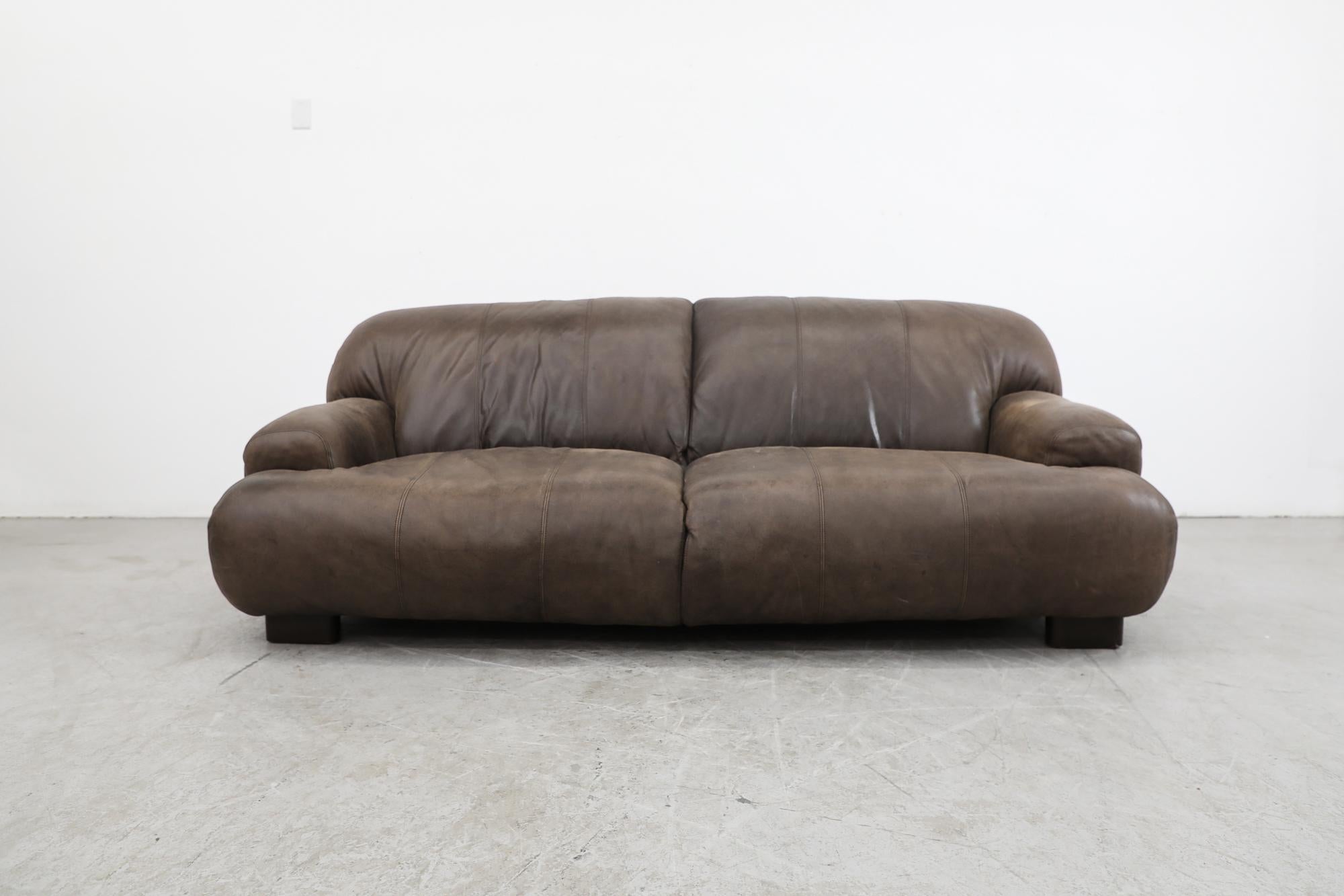 Mid-century De Sede style super stuffed brown leather sofa with deep seating, rounded lines and small arm rests. In original condition with a great patina and fading to the leather, consistent with its age and use. Other leather sofas are available