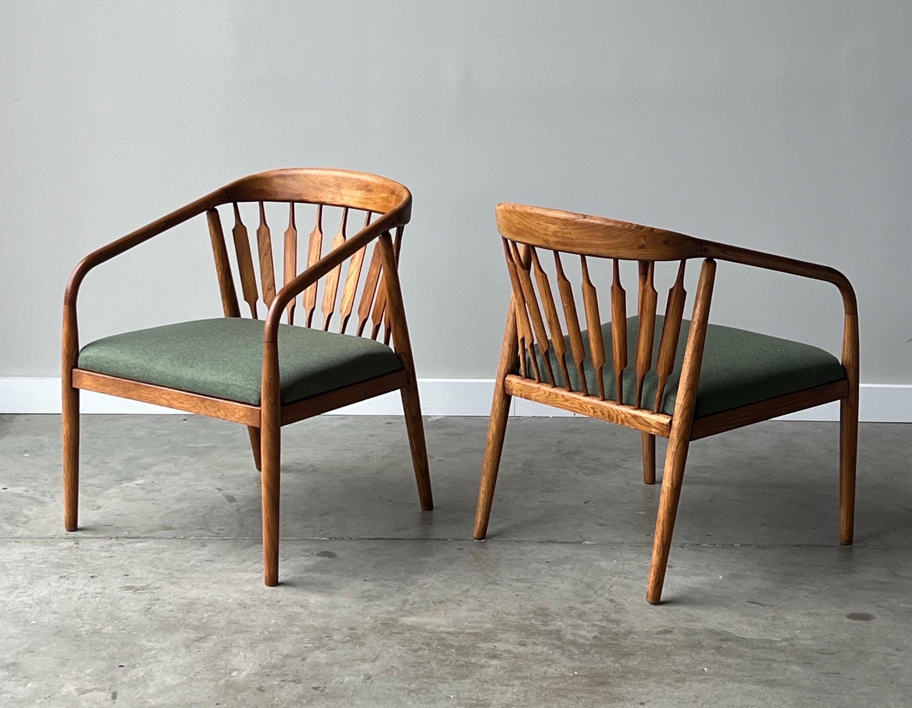 Mid-century seldom seen ‘Declaration’ lounge chairs designed by Kipp Stewart for Drexel, USA. This pair is crafted from oak wood with sculpted round features. Tapered front legs continue into the arms which continue into the backrest as a single