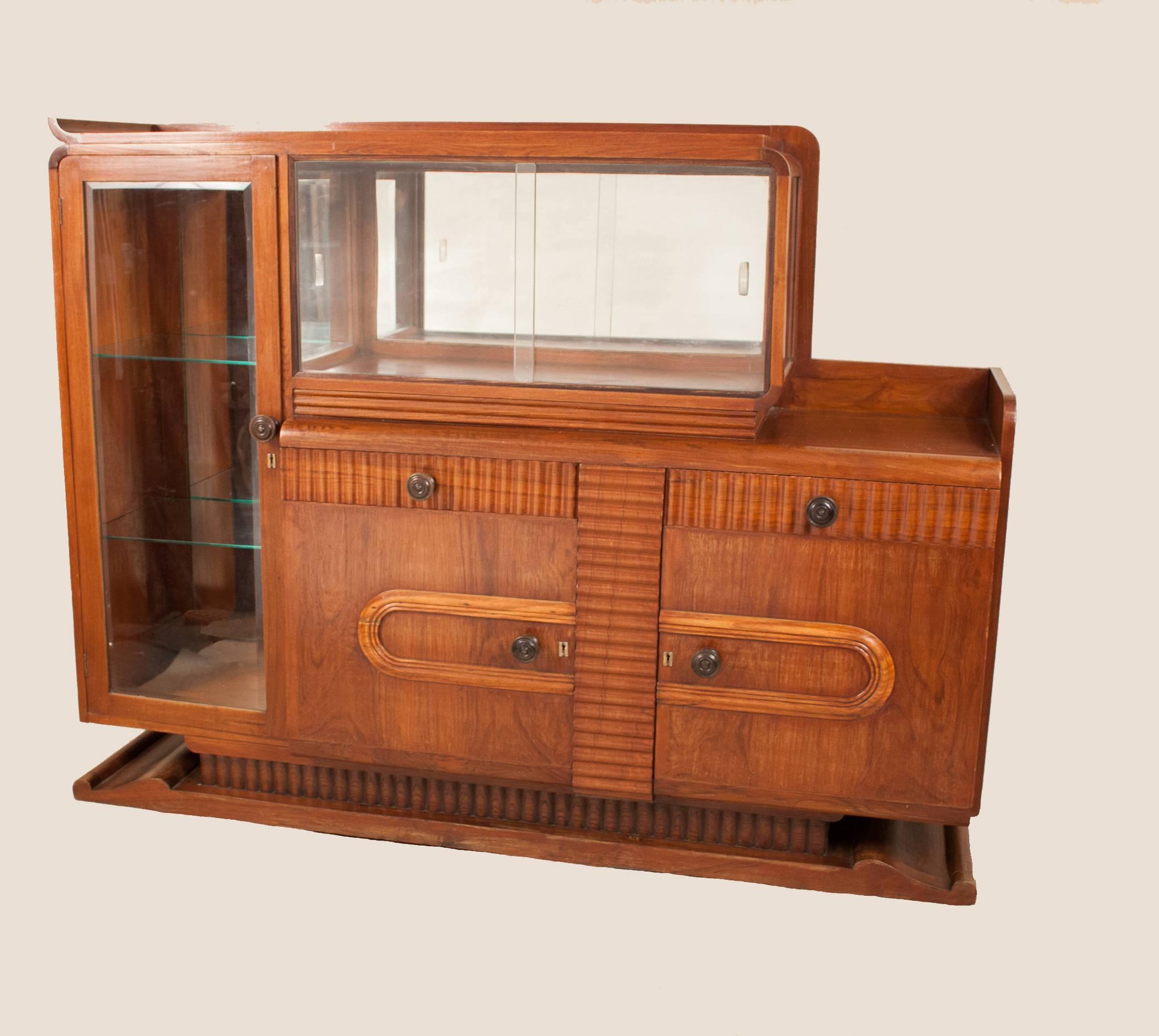 Possibilities abound for this grand 1930s Art Deco credenza handcrafted in India for a visiting French diplomat. The piece is constructed from teak wood, with rosewood accents, and features vertical and horizontal glass display cases with mirrored