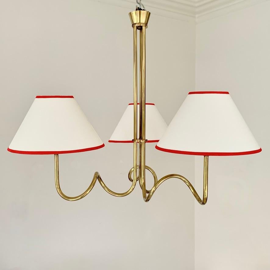 Eleganza francese: lampadario a tre luci in ottone degli anni '50
Volute e curve aggraziate in ottone tubolare, nuovi paralumi in tessuto bianco sporco con un sottile bordo rosso.
L'impianto elettrico è stato controllato da un professionista.
Questo