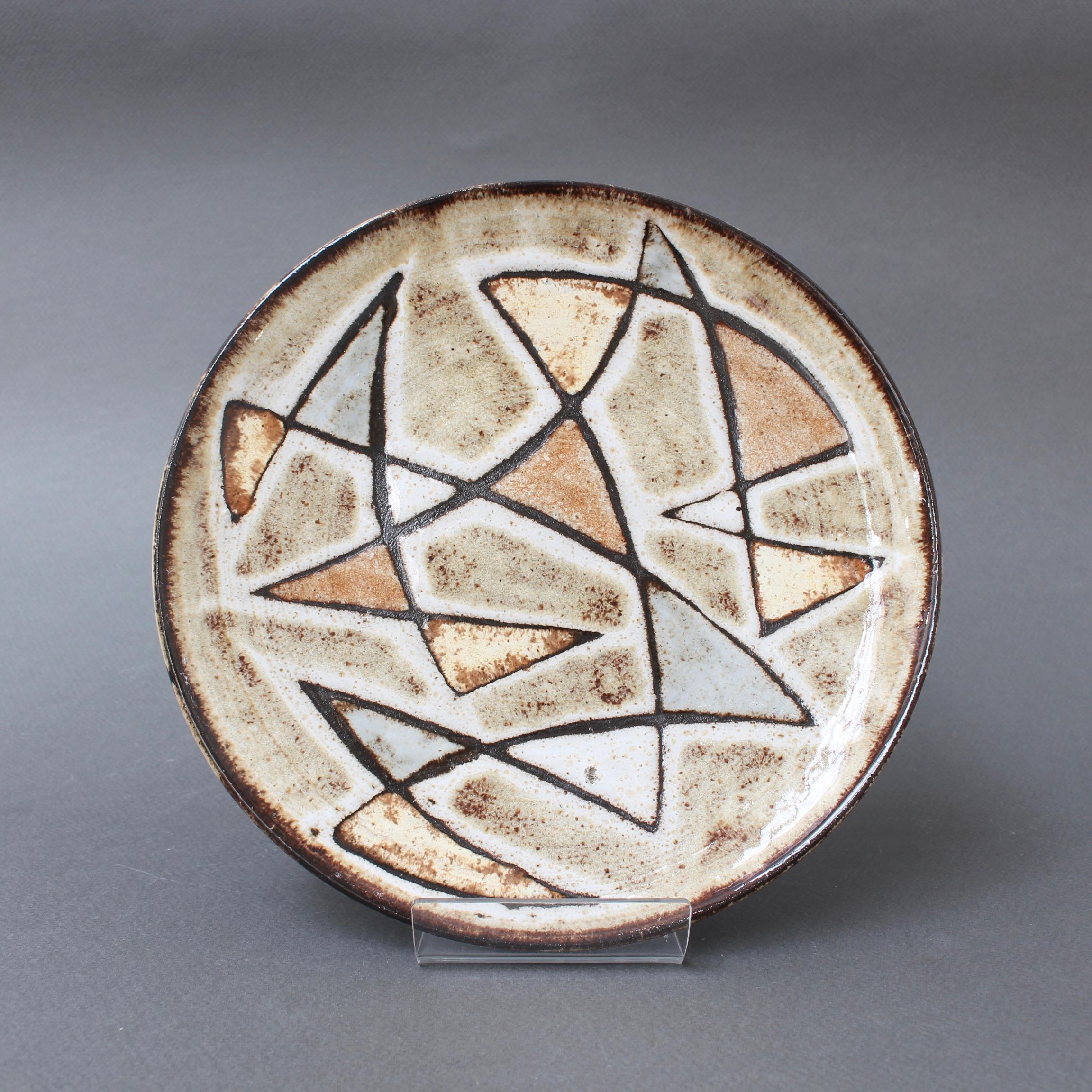Decorative ceramic plate by Robert Perot, founder of the pottery, Vieux Moulin (circa 1950s), Vallauris, France. Exquisite design with geometric shapes in very muted shades of brown, blue, yellow and green. This is an authentic, collectible