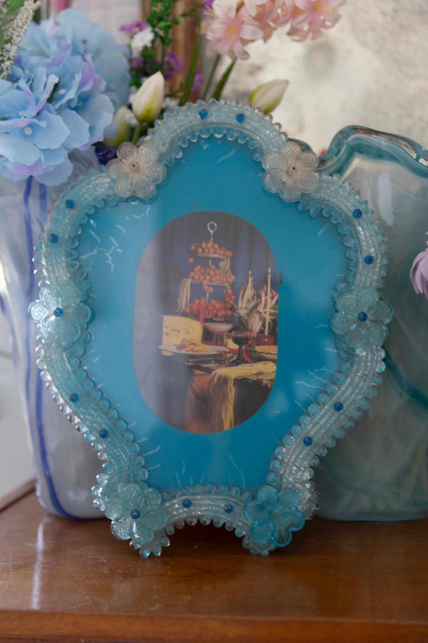 Un magnifique cadre décoratif avec des fleurs d'Italie. Le cadre est en verre et en plastique. Il peut également servir de miroir. Le cadre est en bon état vintage. Il manque quelques fleurs jaunes. Verre d'origine patiné. Une belle pièce pour