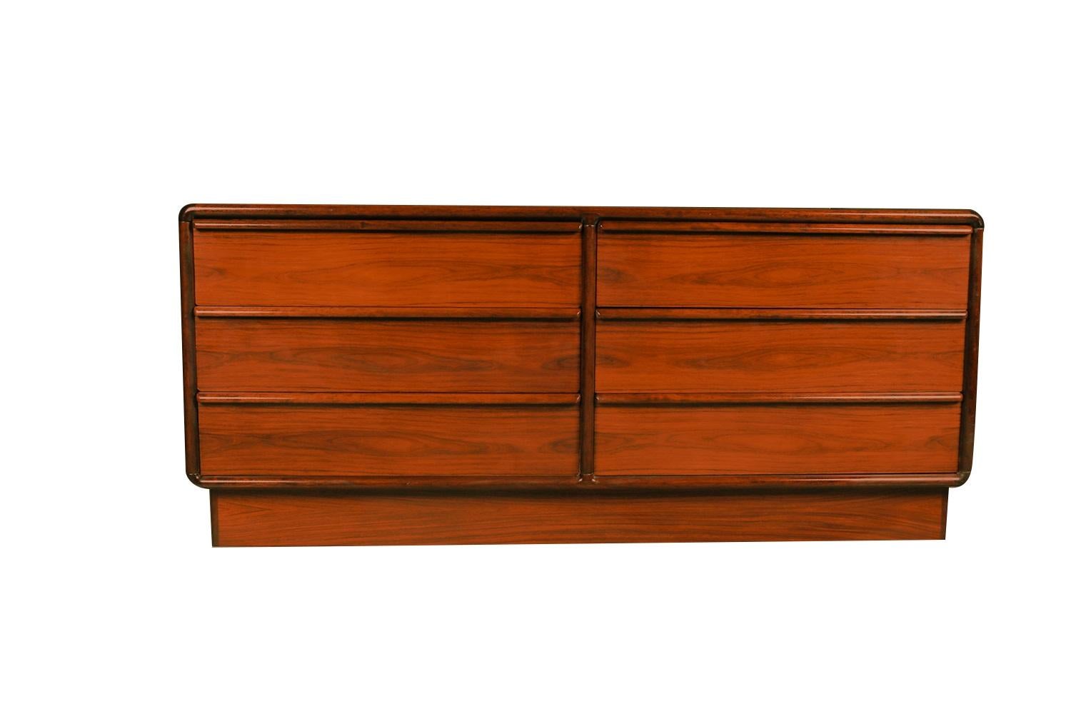 A stunning double rosewood dresser by Kibaek Mobelfabrik, made in Denmark, circa 1960s. This Danish mid century modern rosewood double dresser with six drawers is minimalist in style, with beautifully embellished bands of Rosewood running