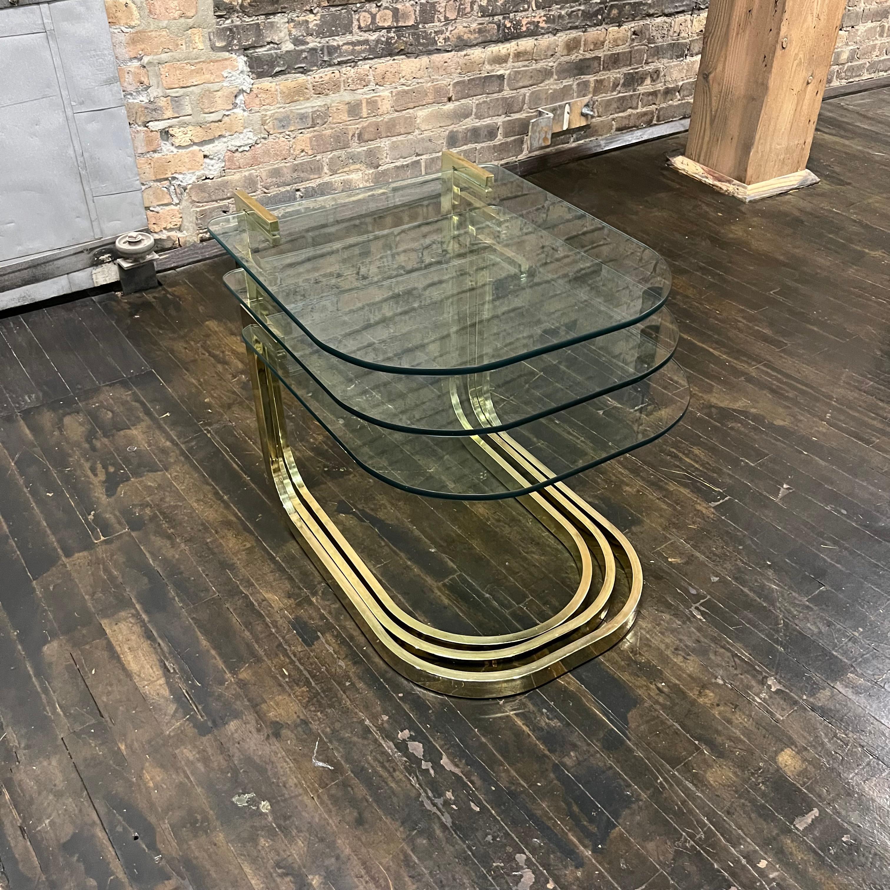 A set of three cantilevered glass and brass nesting tables attributed to Milo Baughman for DIA (Design Institute of America).

Milo Baughman (1923-2003) was a pioneer in modern design and one of the leading modern furniture designers of the second