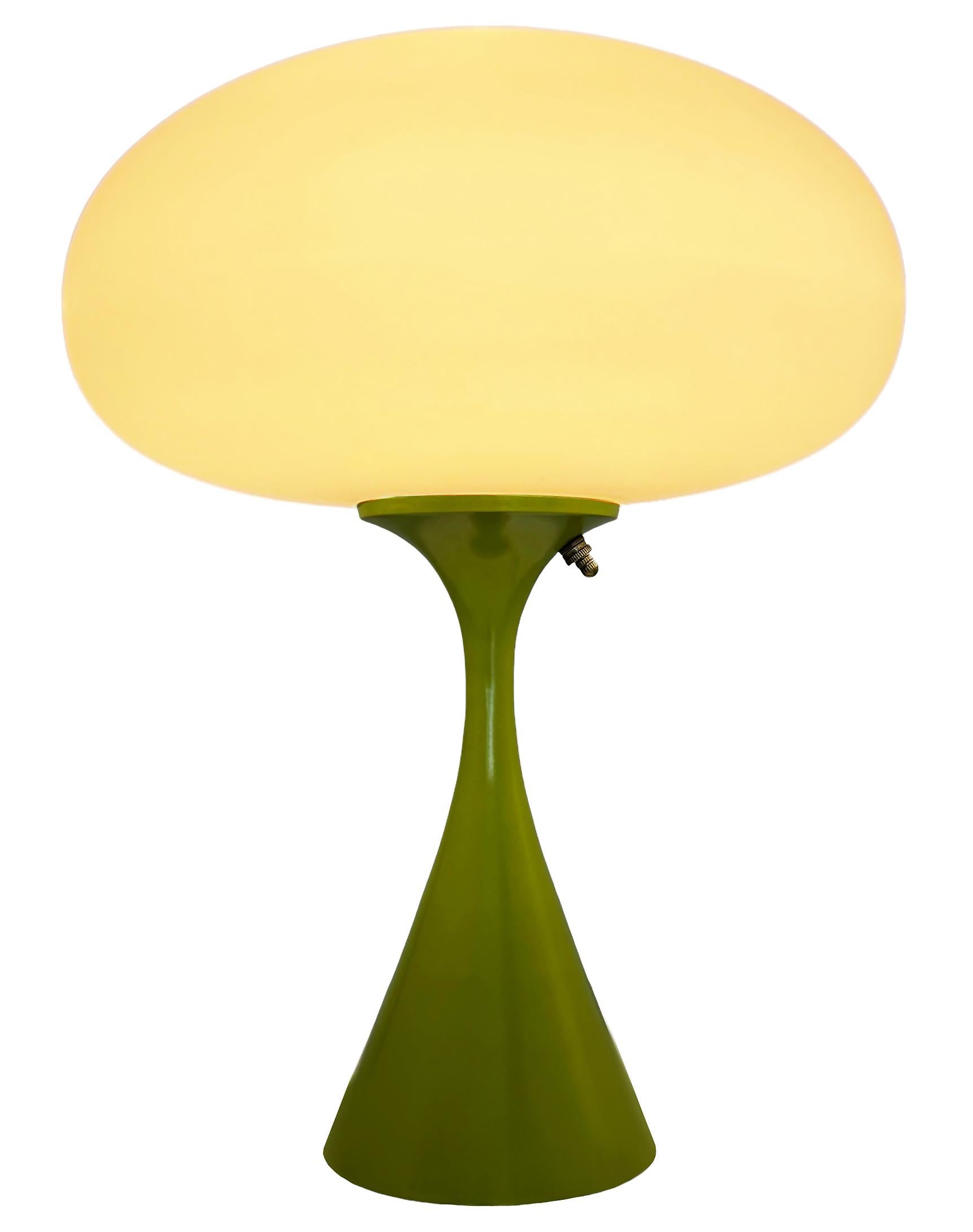 THIS ITEM IS ELIGIBLE FOR FREE SHIPPING!

A sleek stemlite table lamp made by Design Line. It features a cast aluminum main base in a conical form. The lamp base is finished in a classic retro avocado green color. The frosted glass lamp shade is