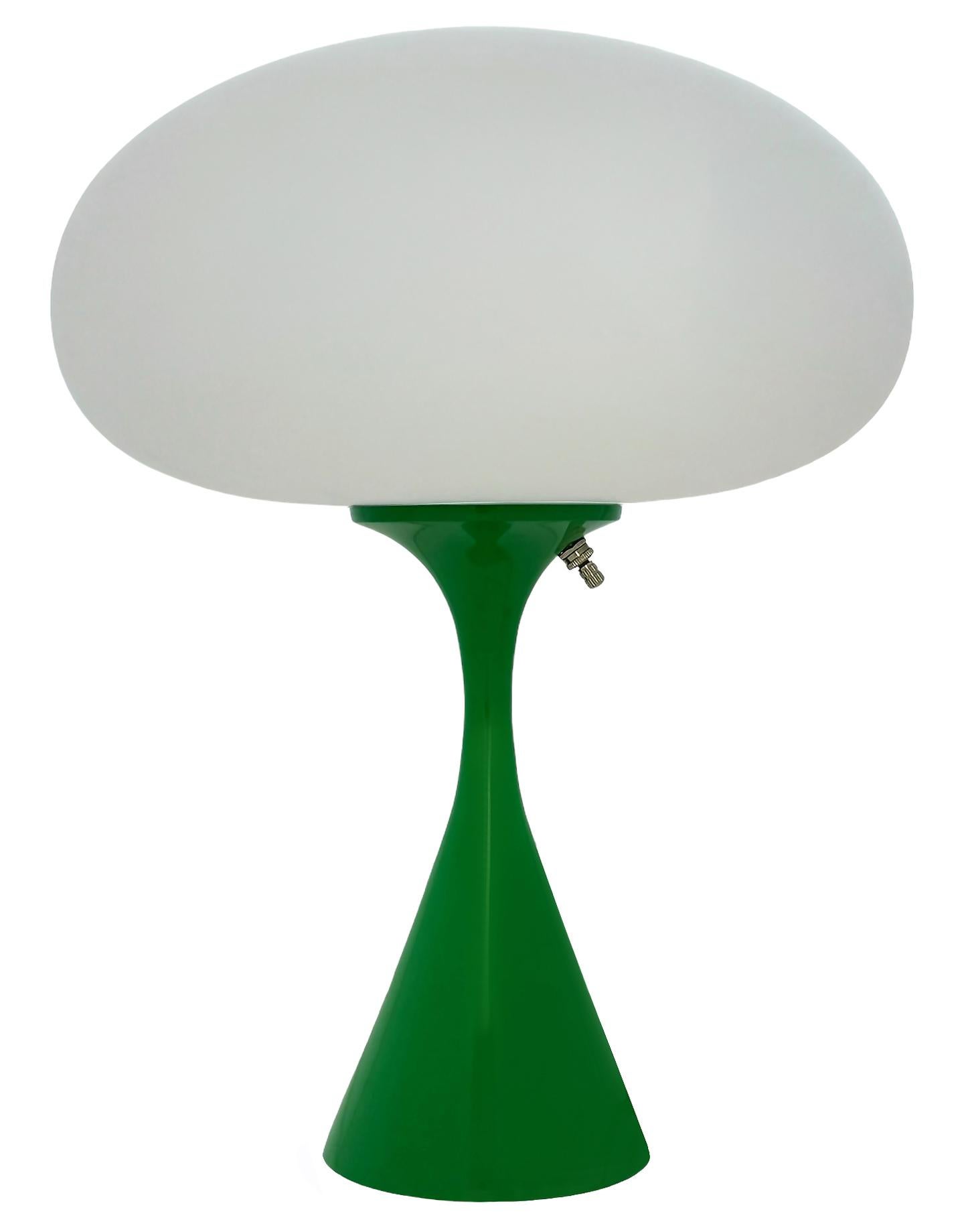 THIS ITEM IS ELIGIBLE FOR FREE SHIPPING!

A sleek stemlite table lamp made by Design Line. It features a cast aluminum main base in a conical form. The lamp base is finished in a retro green color. The frosted glass lamp shade is hand blown and