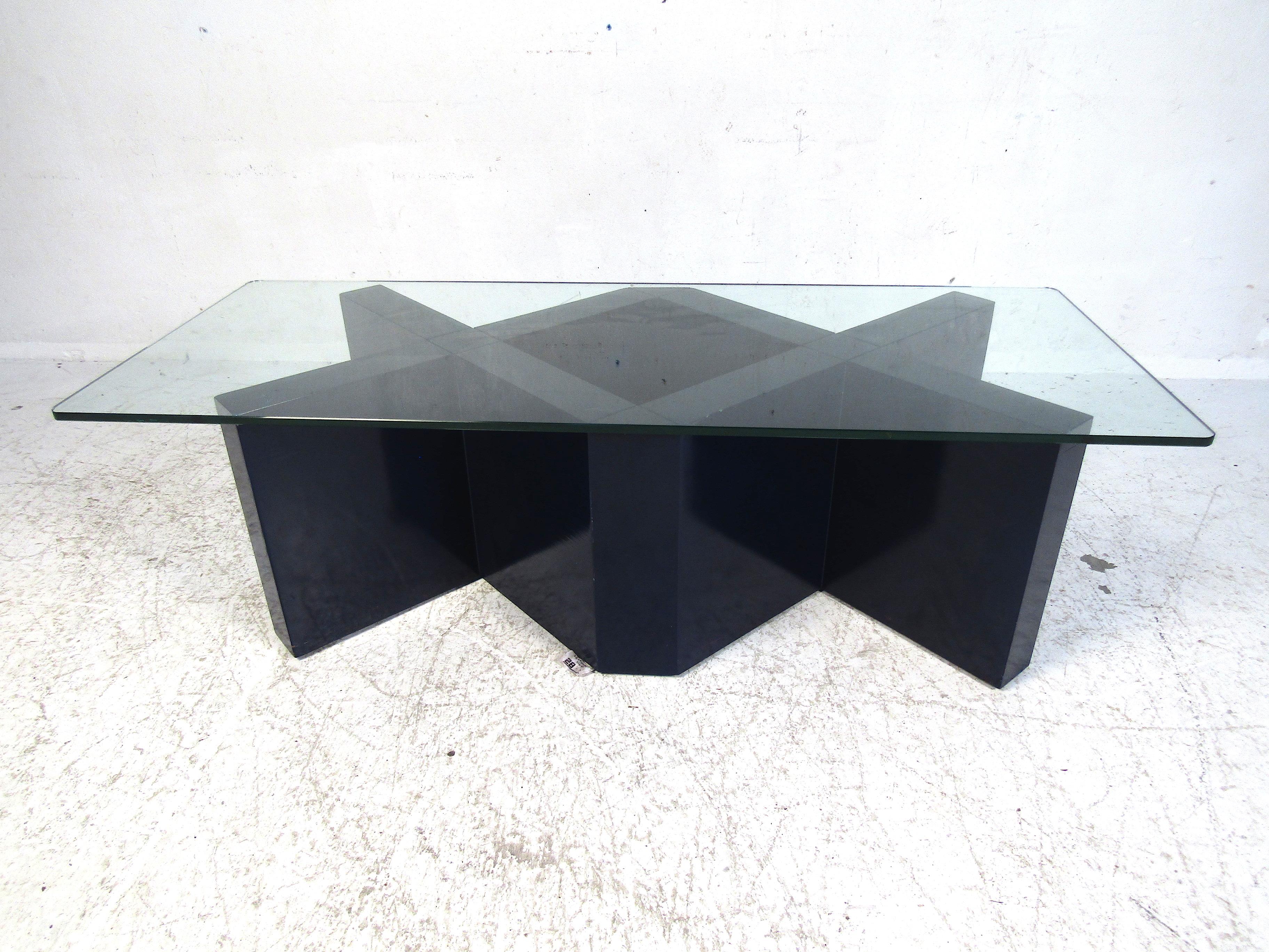 This incredibly unique coffee table features a wood base with a thick glass top. Perfect for any modern living room or TV room. This piece is sure to strike a conversation every time someone sees it. Please confirm the item location with the dealer.
