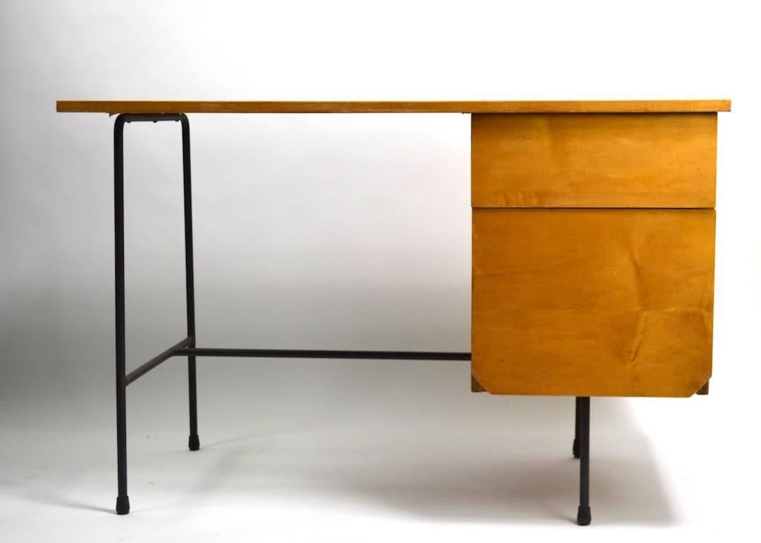 Rare desk designed by Clifford Pascoe, selling with original desk chair. The desk has a faux wood Formica top, blonde wood drawers and black wrought iron legs. Two drawers, lower drawer is deeper than the top drawer. Dimensions for chair as follows