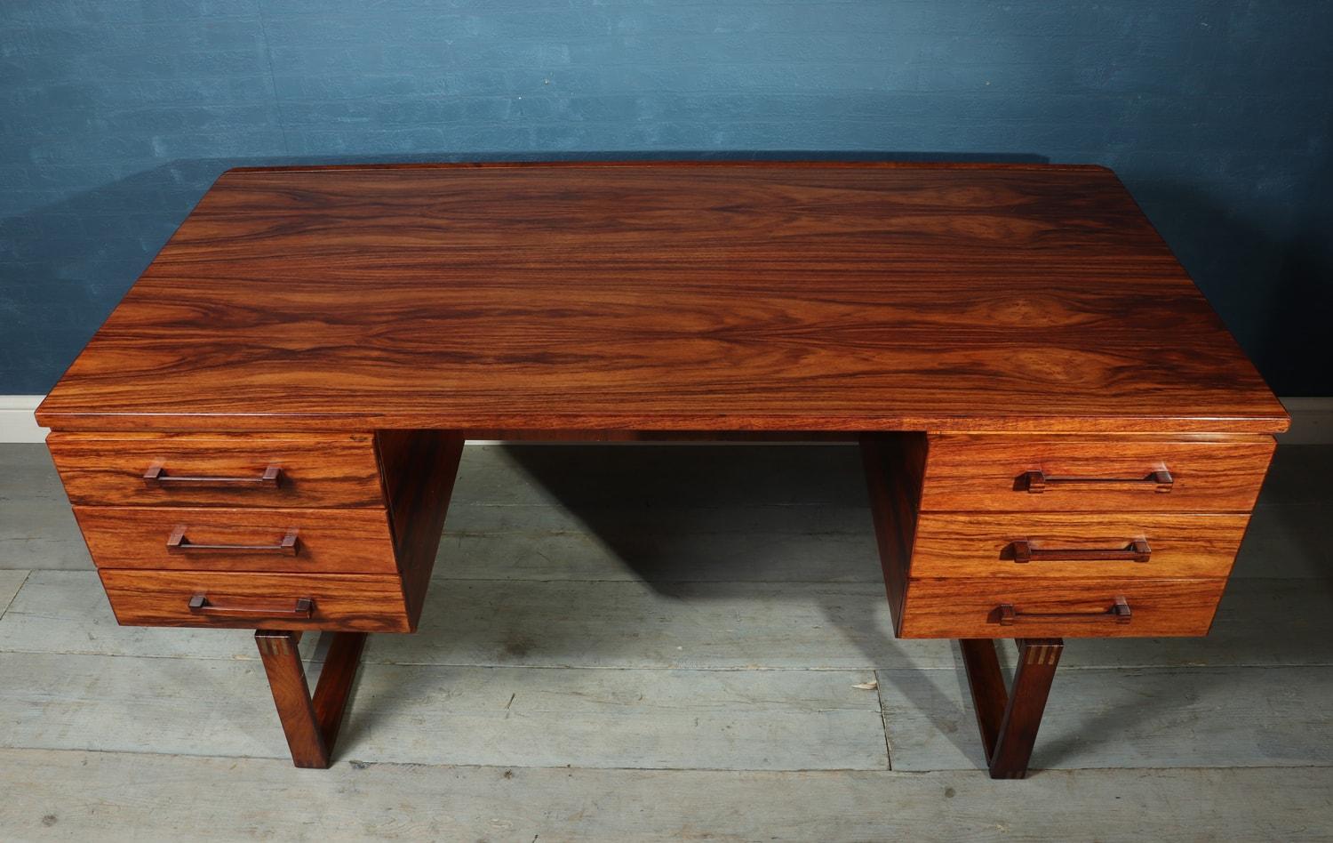 Midcentury desk by Henning Jensen
Designed by Henning Jensen and Torbin Valeur in Denmark in the mid-1960s. This rosewood desk has beautiful graining and the exposed finger joint construction. Highlighted by a subtle raised lip along the back edge,
