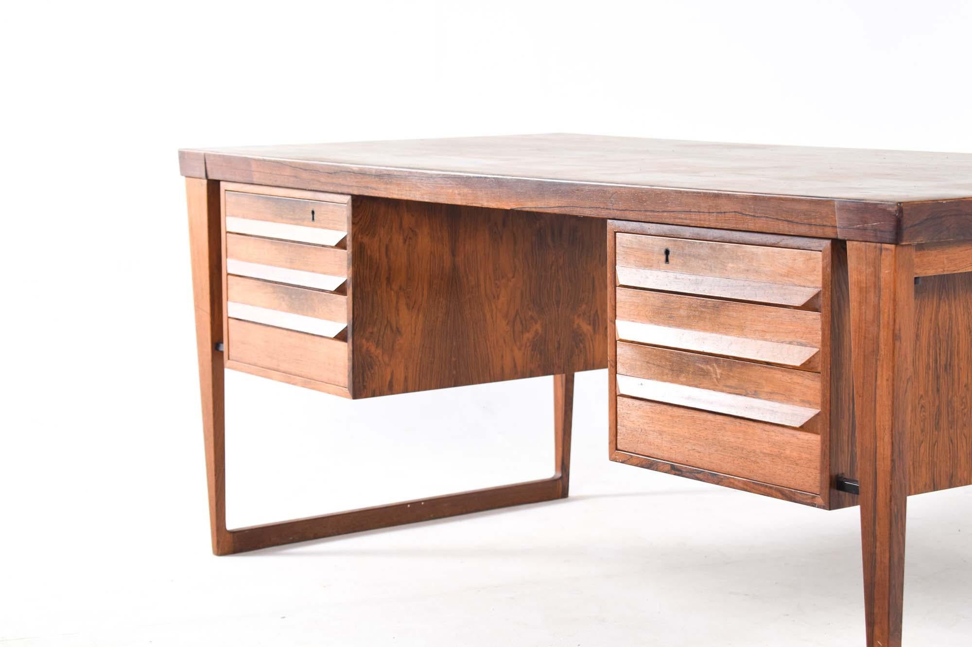 Kai Kristiansen design this large desk in 1950s for Feldballe Mobelfabrik. Iconic Model 70. The desk have six drawers on the front and two doors on the backside. This executive desk was crafted in rosewood and features a large surface top supported