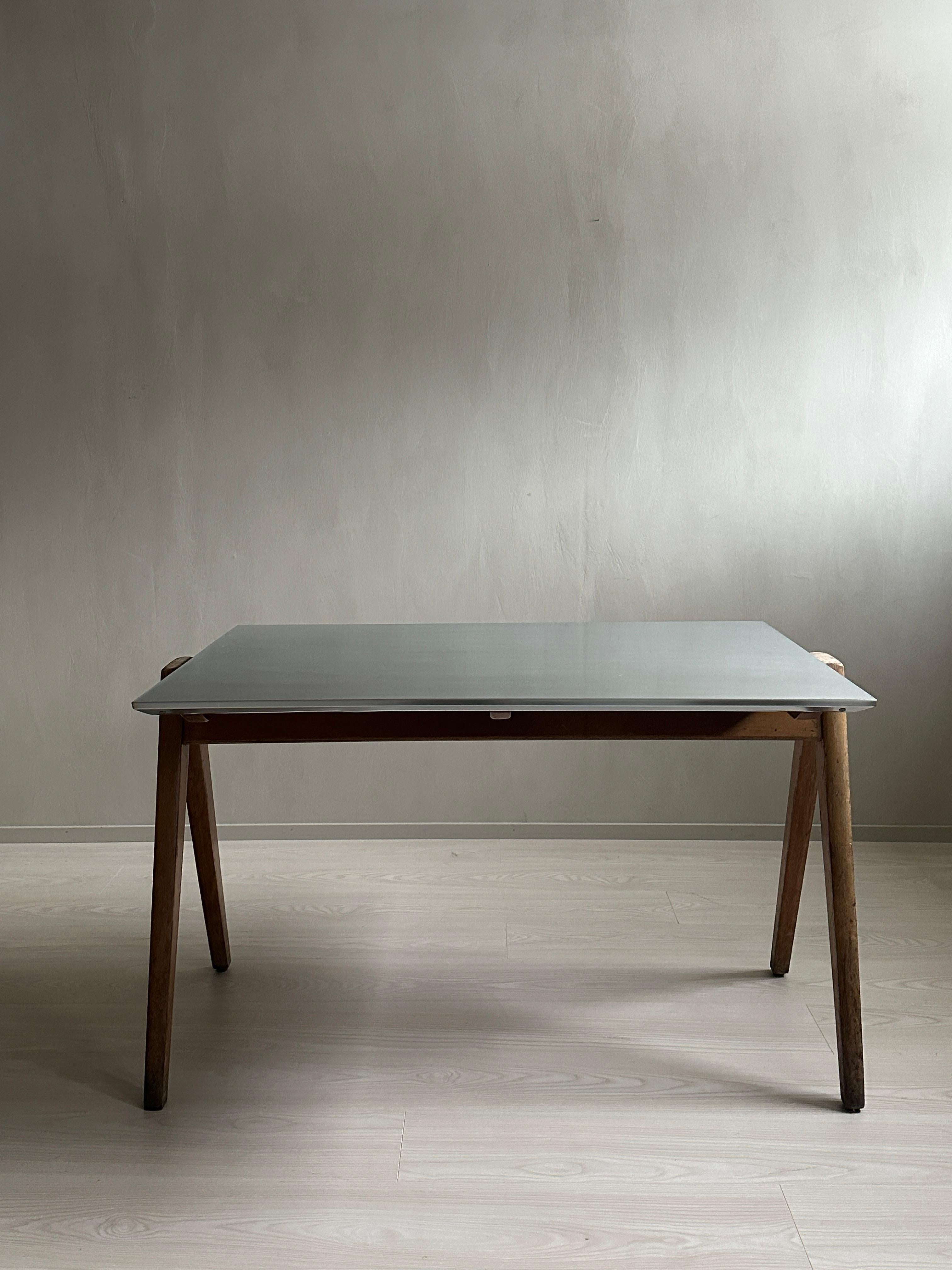This midcentury desk is designed by renowned designer Robin Day, known for his contributions to modern furniture design. 

The desk is characterized by its sleek and minimalist aesthetic, featuring a zinc top that adds a touch of industrial flair.