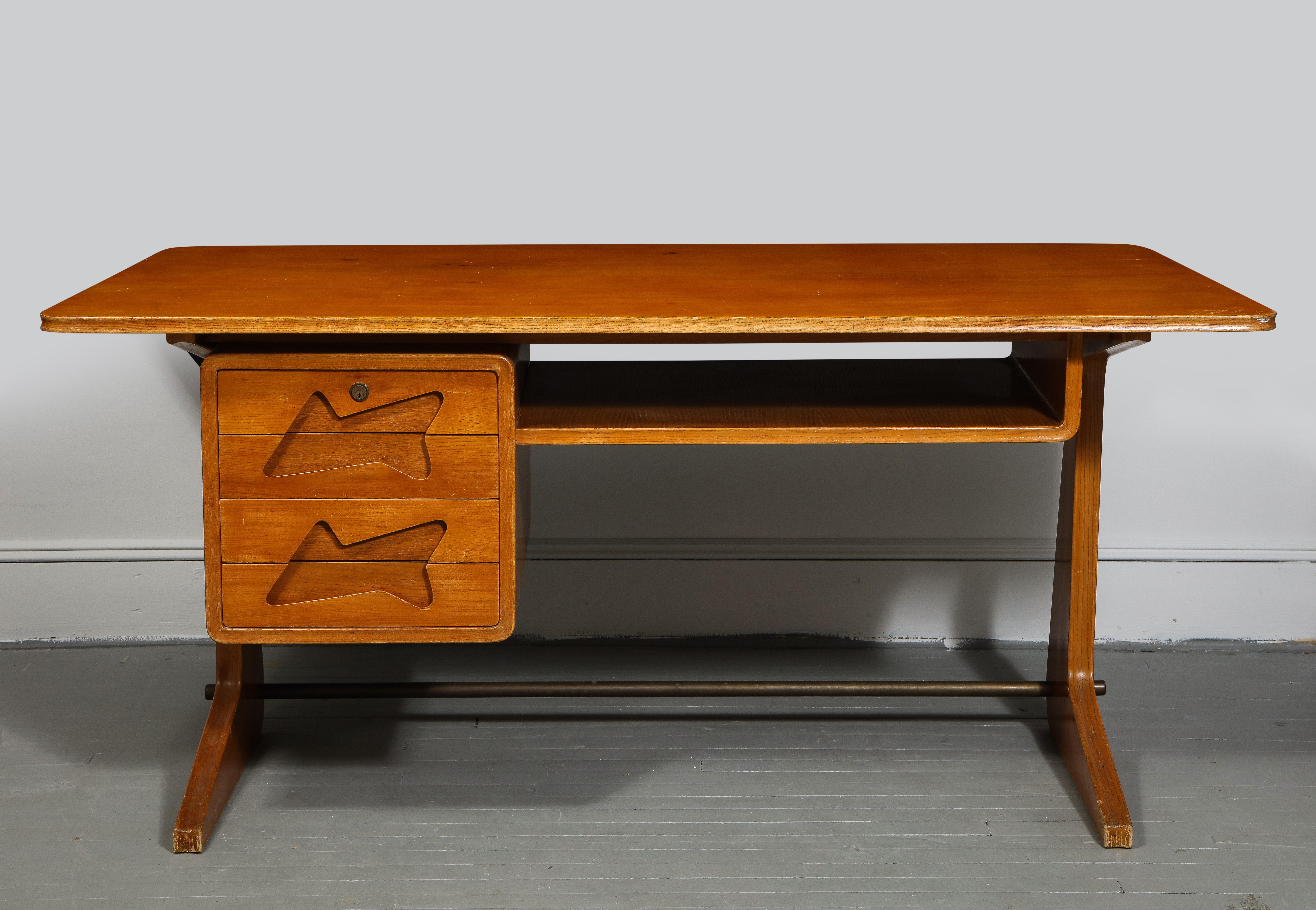 Exquisite mid-century desk in the manner of Gio Ponti, Italy, circa 1950s. 

Stunning and inventive design consists of two drawers with fantastic cut-out handles, angular desk top with generous surface space, one open shelf, and handsome feet