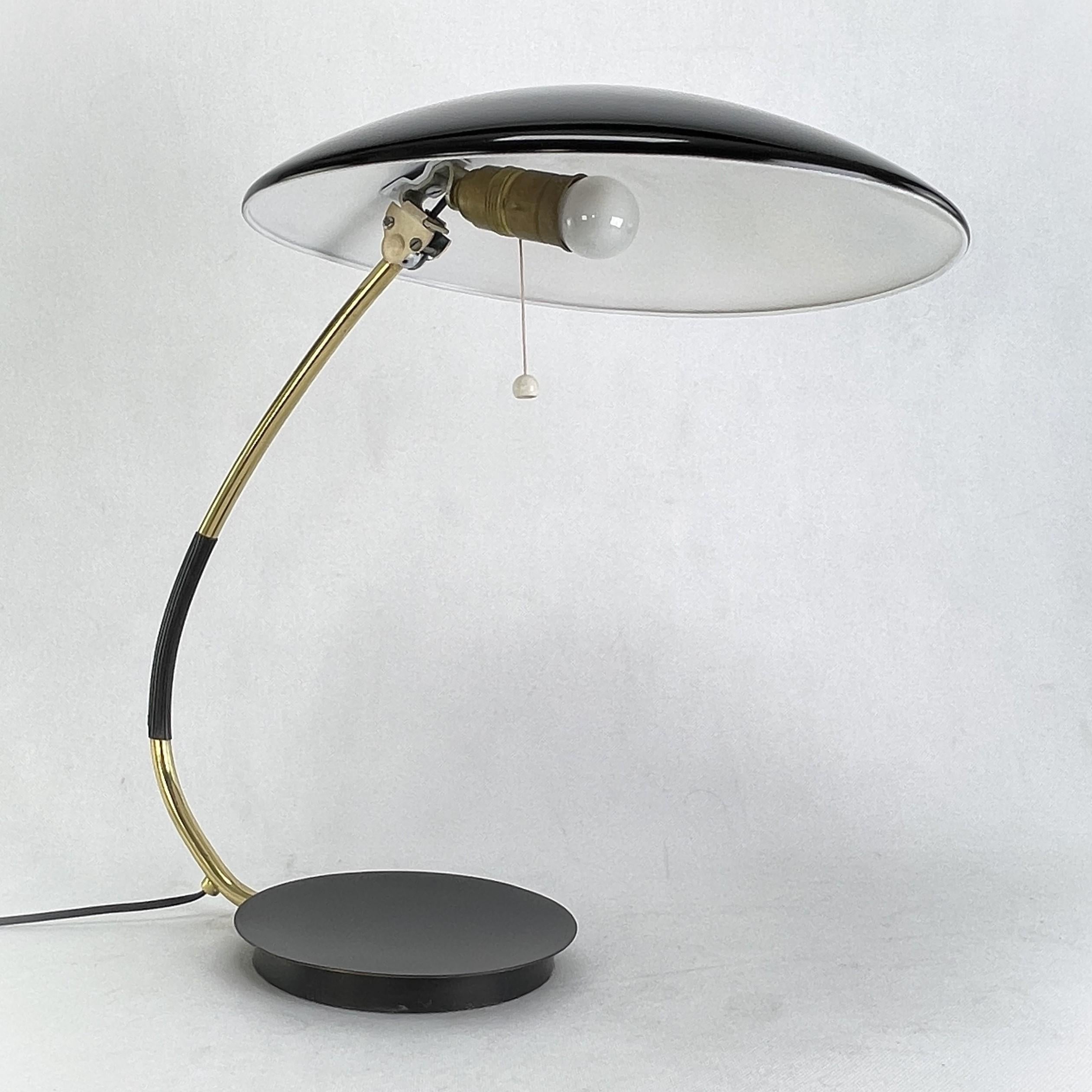 Table Lamp from Kaiser Idell - 1950s.

This black and gold desk lamp was produced in the midcentury era. The Kaiser Idell lamp is a design by Christian Dell. The lamp with the modell number 6787 still impresses with its simple bauhaus