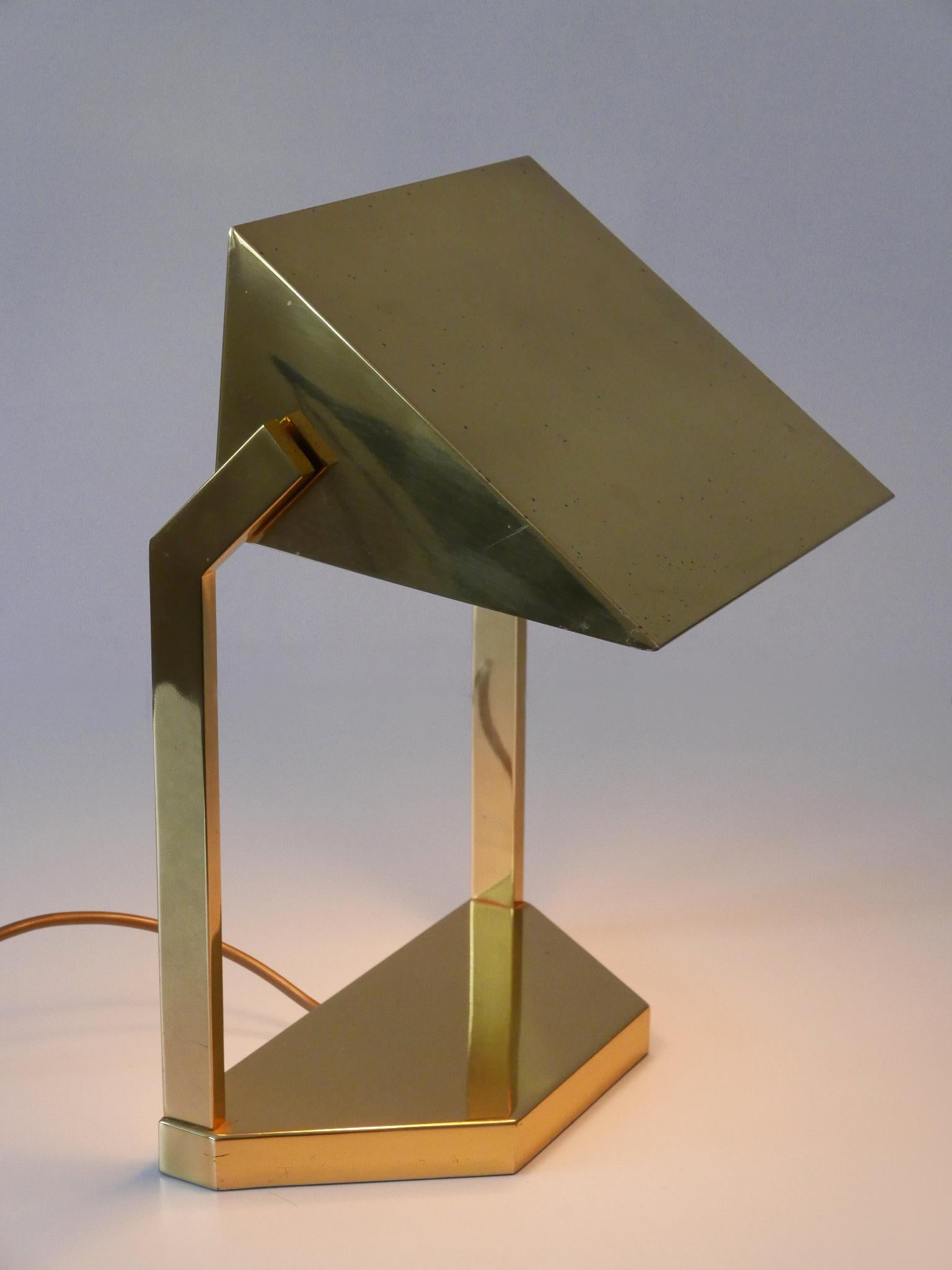 Rare and elegant Mid-Century Modern desk light or table lamp with adjustable shade. Designed and manufactured by Vereinigte Werkstätten München, Germany, 1960s.

Executed in heavy solid brass and lucite, the lamp comes with 2 x E14 / E12 Edison