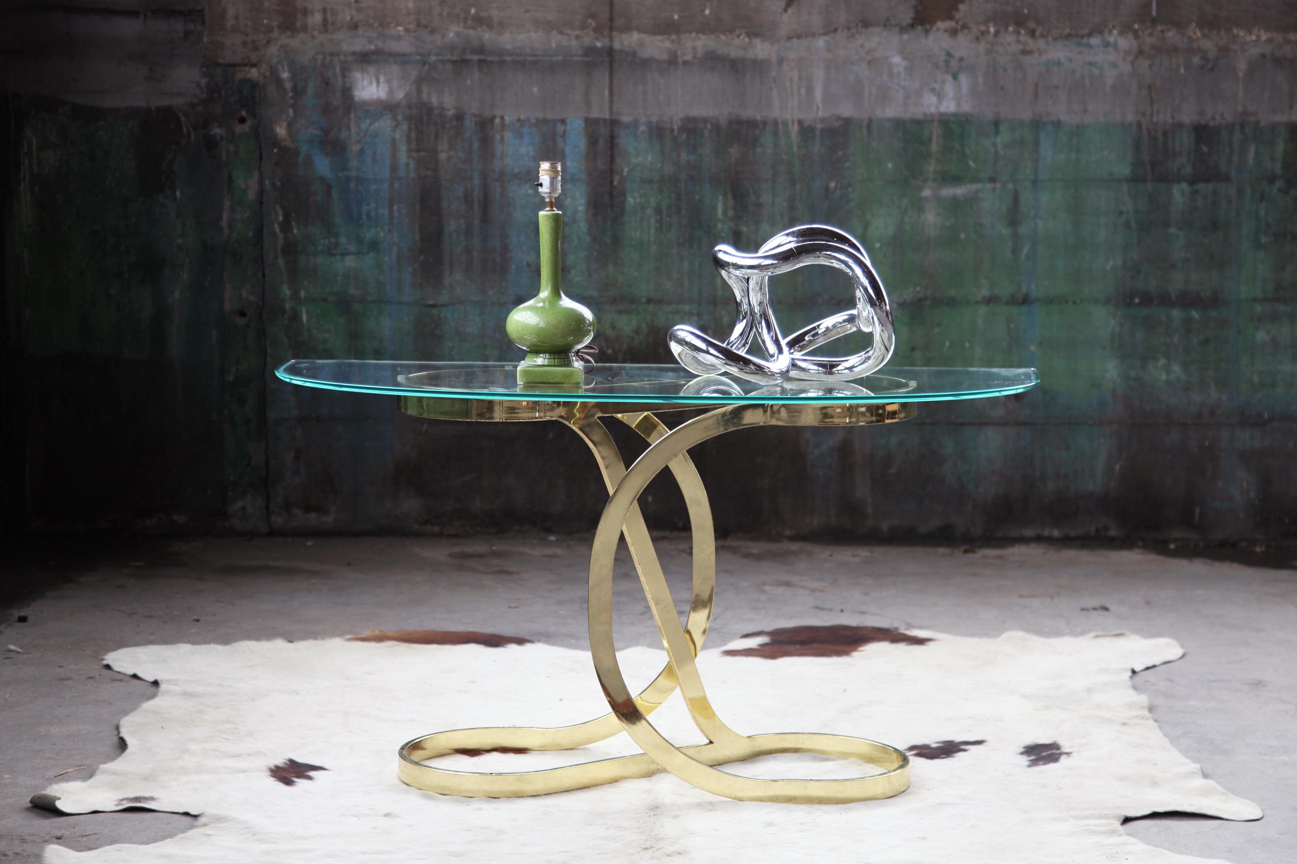 This Mid-Century Modern side / end console table features Classic bent brass framework with a beautiful and very high quality beveled glass top. Attributed to American designer Milo Baughman, and acquired from the personal collector of a designer
