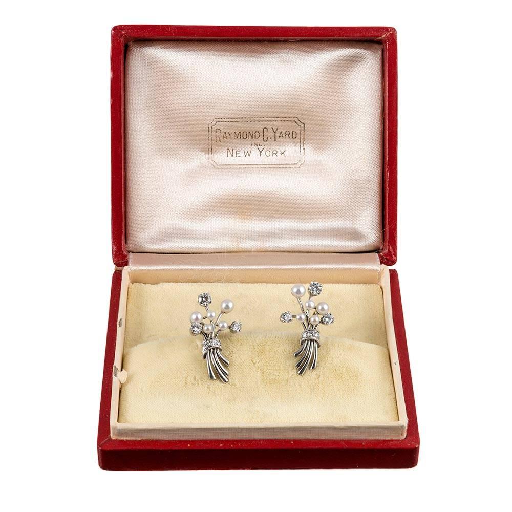 Nestled in their original red Raymond Yard presentation box, these sweet earrings are fashioned as a bouquet of diamond and pearl flowers made of platinum with 14k white gold screw backs for unpierced ears. At 1 inch long, these charming adornments