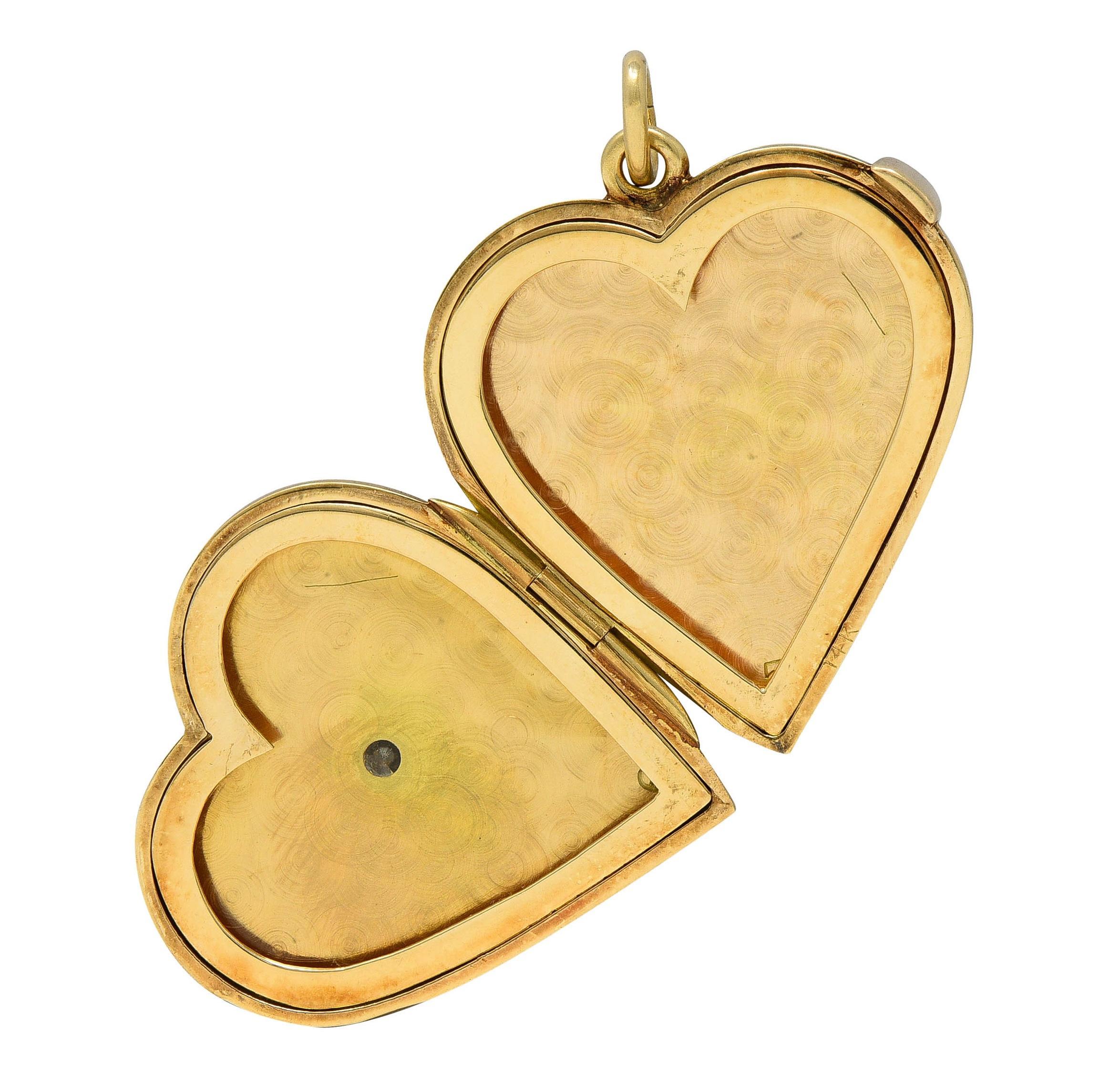 Designed as a heart-shaped locket pendant suspending from a jump ring bale
Front and back of locket is engraved with a radial linear pattern
Centering a bezel set transitional cut diamond on front
Weighing approximately 0.60 carat total - G color