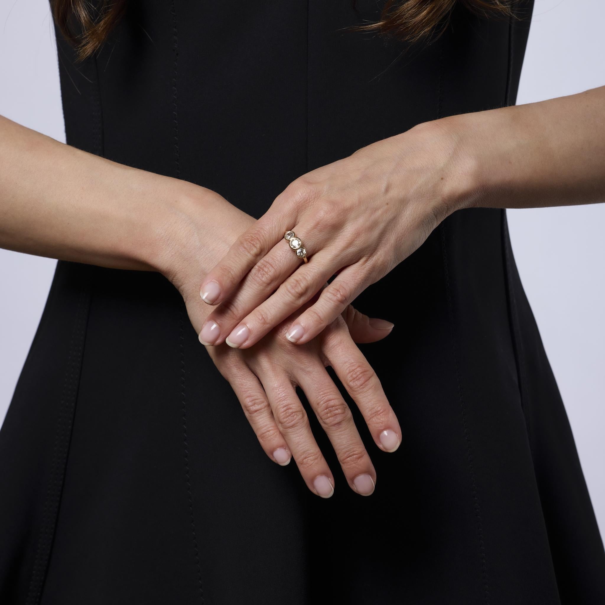 This elegant Mid Century three-stone ring features three glowing old mine cut diamonds set in rich 18k yellow gold. A timeless design from the 1950s that blends vintage sparkle with classic sophistication.