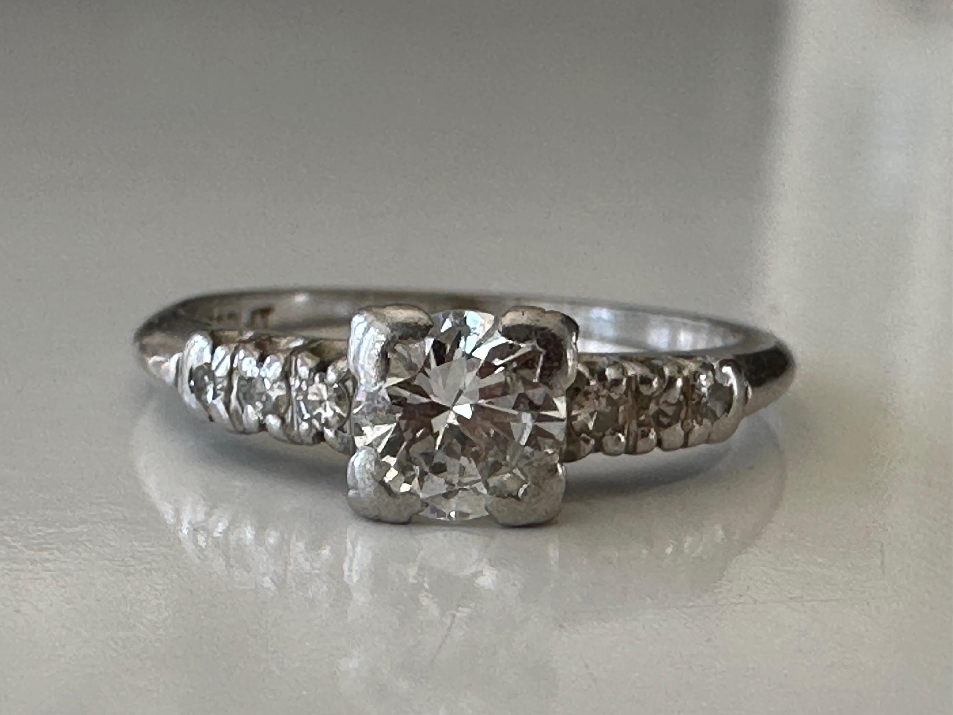Handcrafted in the 1940s in platinum, this stunning Mid-century ring is designed around an Old European cut diamond center stone measuring approximately 0.50 carats, H color, SI1 clarity, and flanked by six single cut diamonds, three on each side,