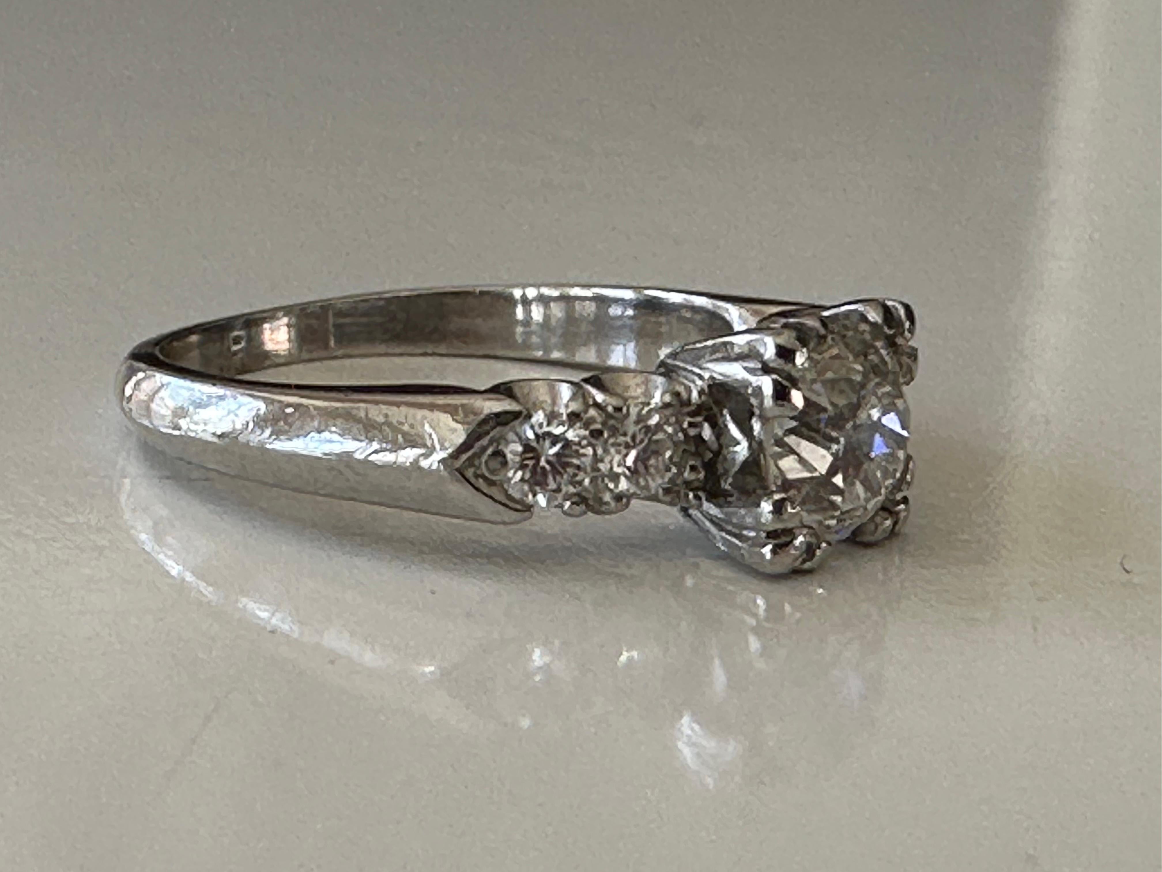 Handcrafted in platinum, this stunning mid-century ring is designed around an Old European cut diamond center stone measuring approximately 0.62 carats, G color, SI2 clarity, and flanked by four single cut diamonds, two on each side, totaling