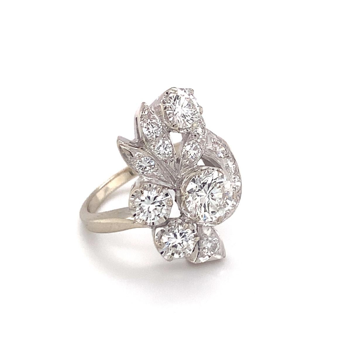 One mid-century diamond cluster dinner ring in 14K white gold centering one round brilliant cut diamond weighing approximately 1.06 ct. with 14 round brilliant cut diamonds surrounding totaling approximately 1.73 ct. 

Floral, shimmering,