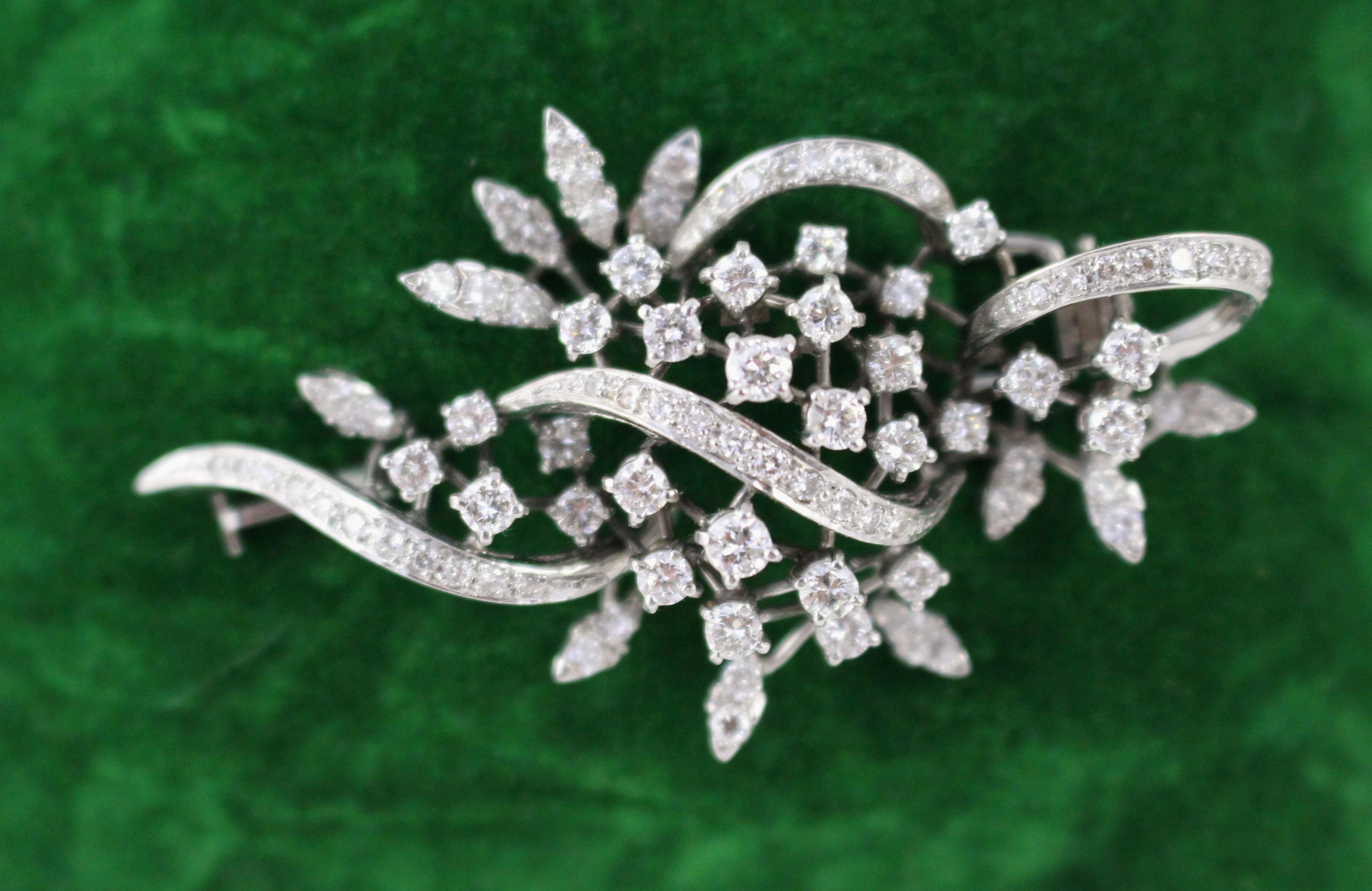 Spilla a fogliame con diamante di metà secolo in oro bianco 18 carati

Una raffinata e splendida spilla con diamante della metà del XX secolo, realizzata in oro bianco 18ct. Disegnata con un elegante motivo a volute fogliate, la spilla presenta una