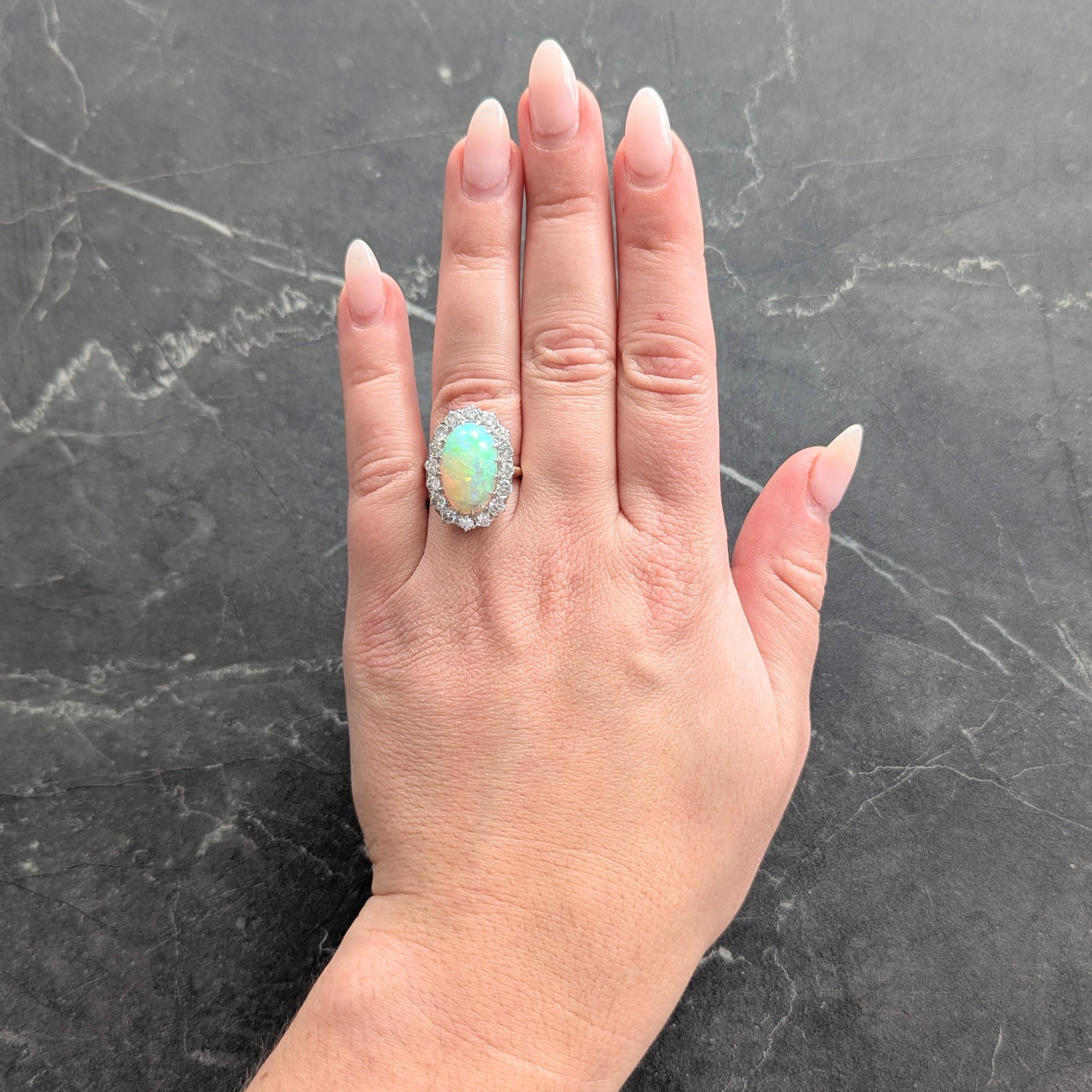 Al centro un cabochon di opale gelatinoso di forma ovale di 10,0 x 16,0 mm.
Colore del corpo bianco semitrasparente con gioco di colori spettrale
Incastonato con rebbi a forma di talone in platino e circondato da un'aureola di diamanti
Taglio di